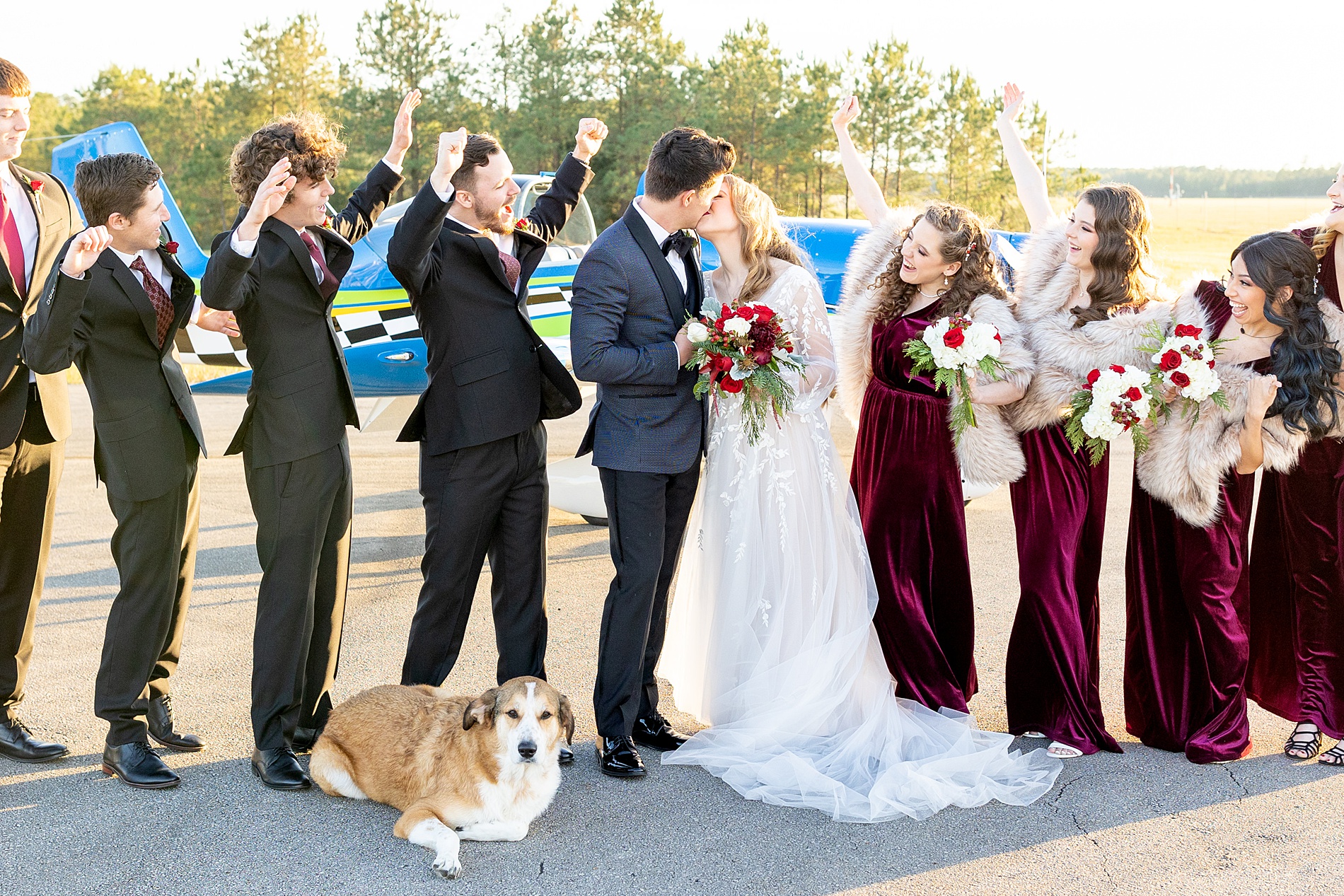 bride and groom kiss surrounded by bridal party