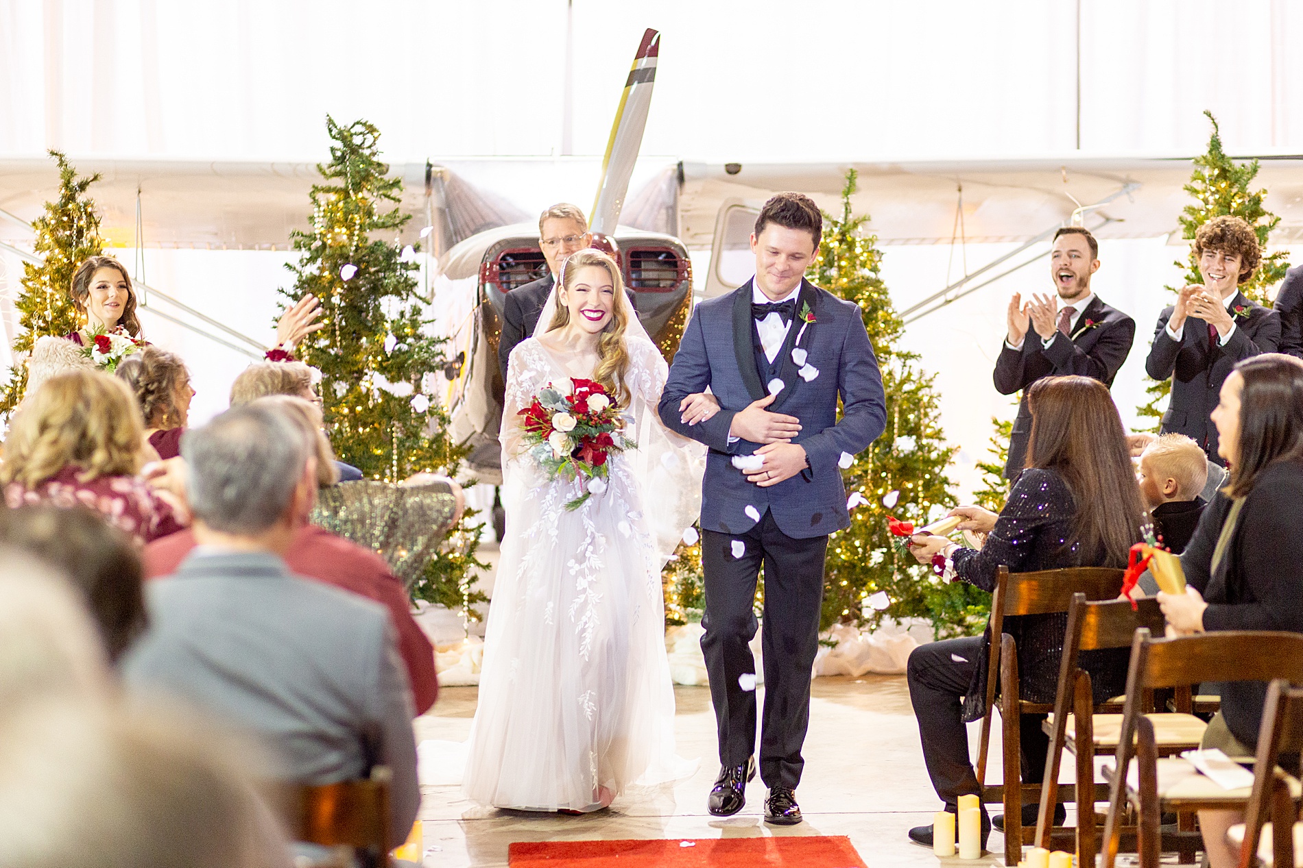 guests throw rose petals as newlyweds exit ceremony
