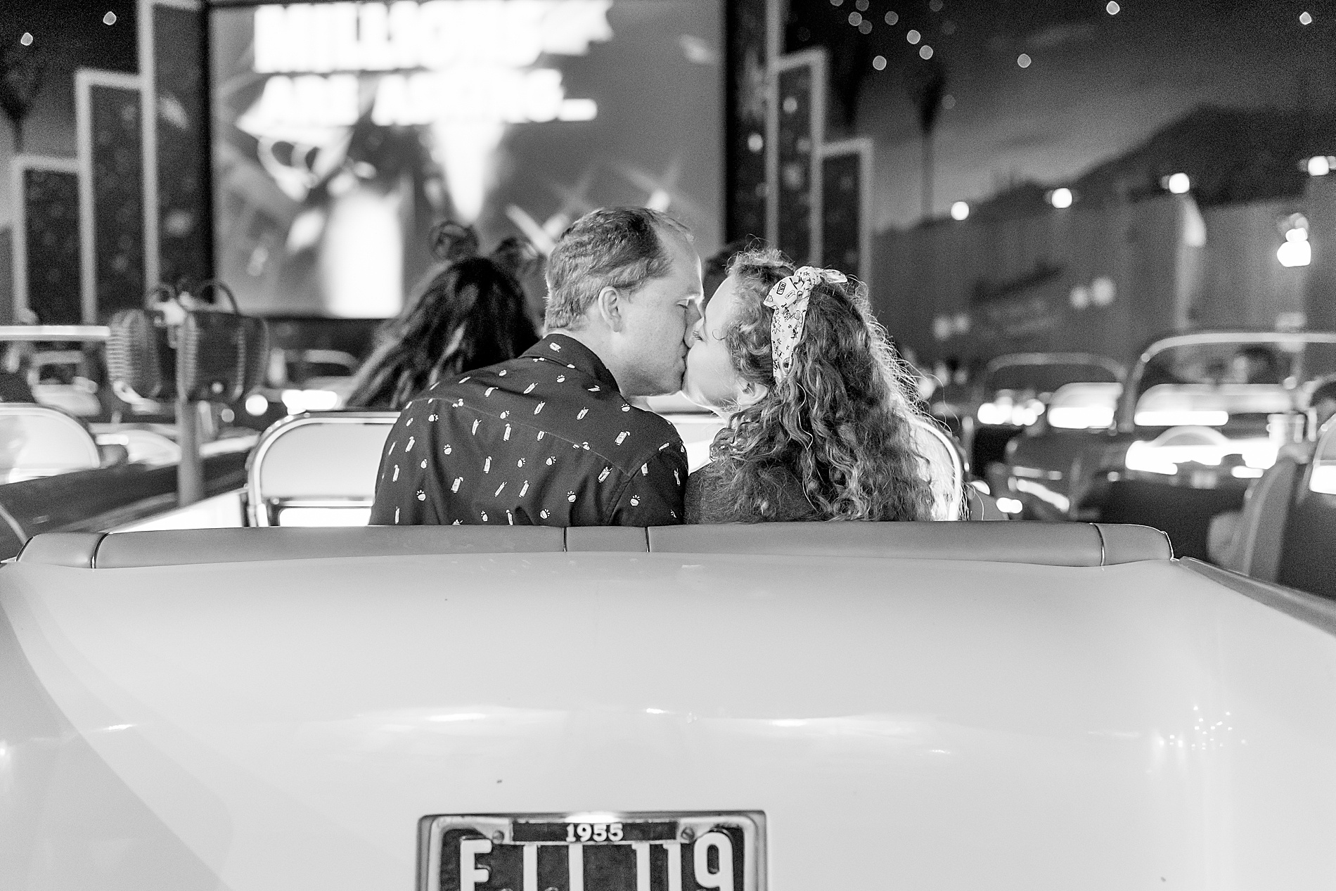 couple kiss in back of car at outdoor restaurant at Disney 