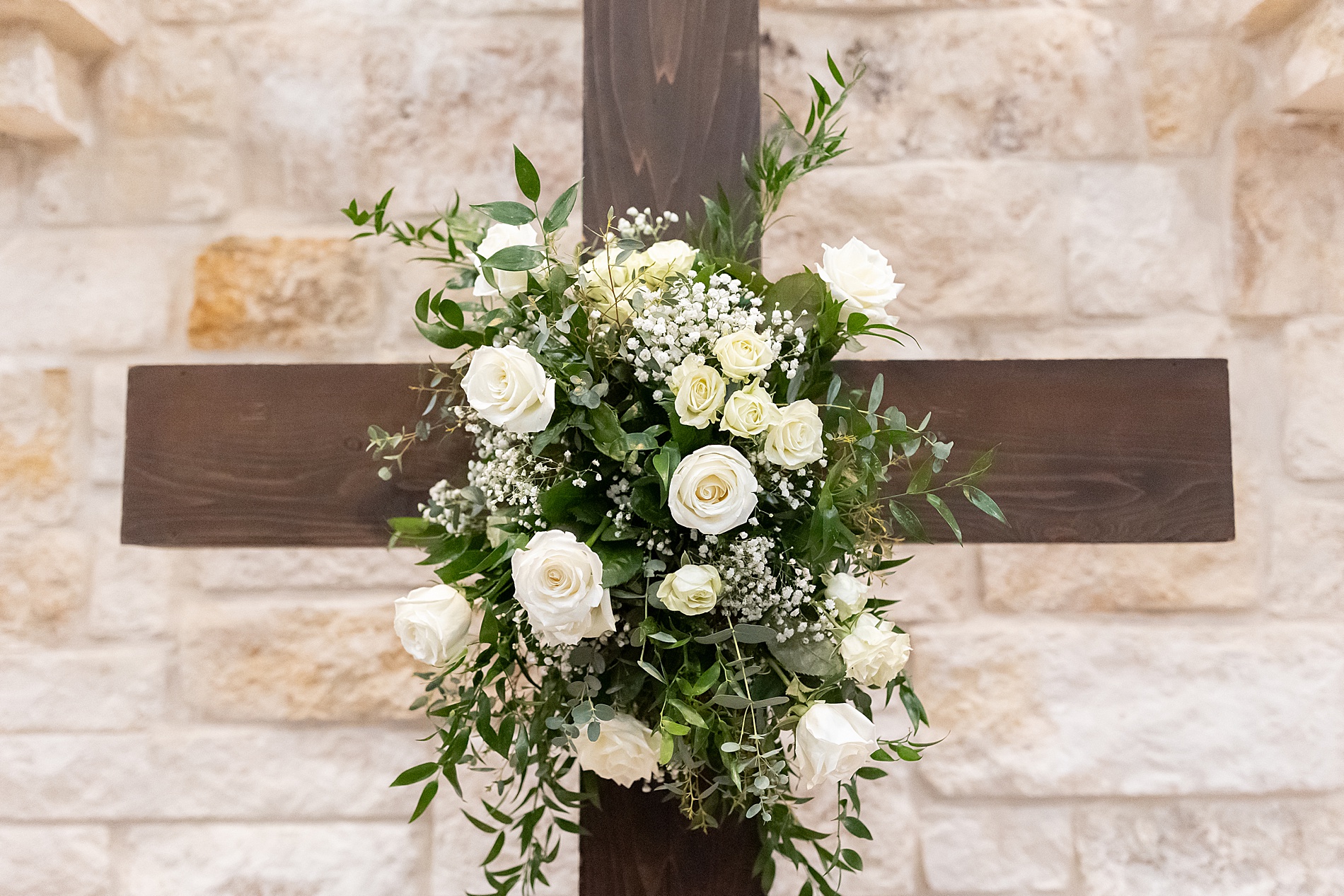 cross with white flowers from wedding ceremony 