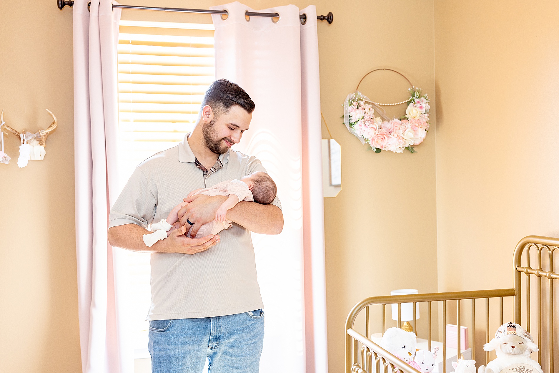 dad in nursery holding newborn girl
