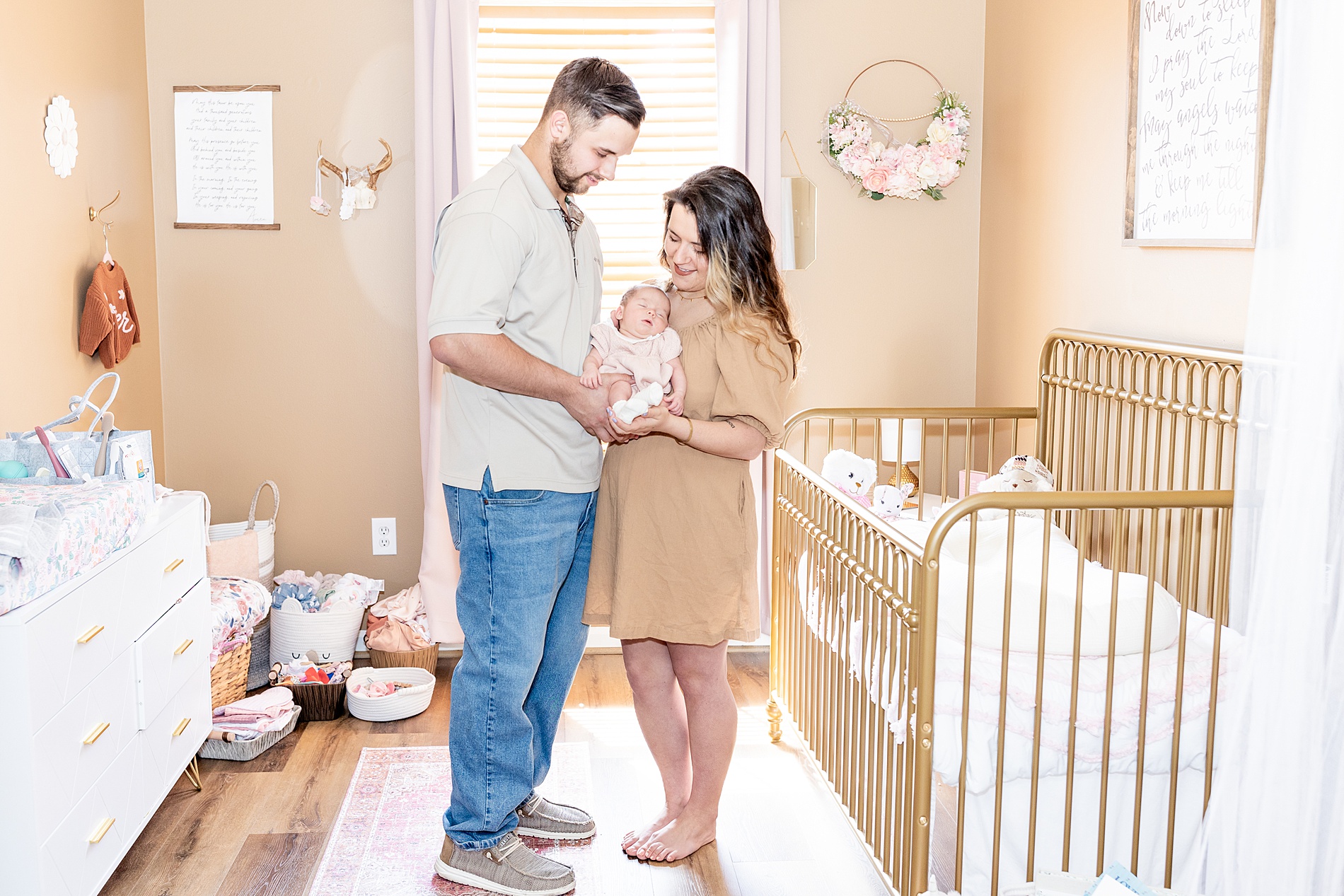 parents hold newborn girl in nursery during Greenville In-Home Newborn Session 