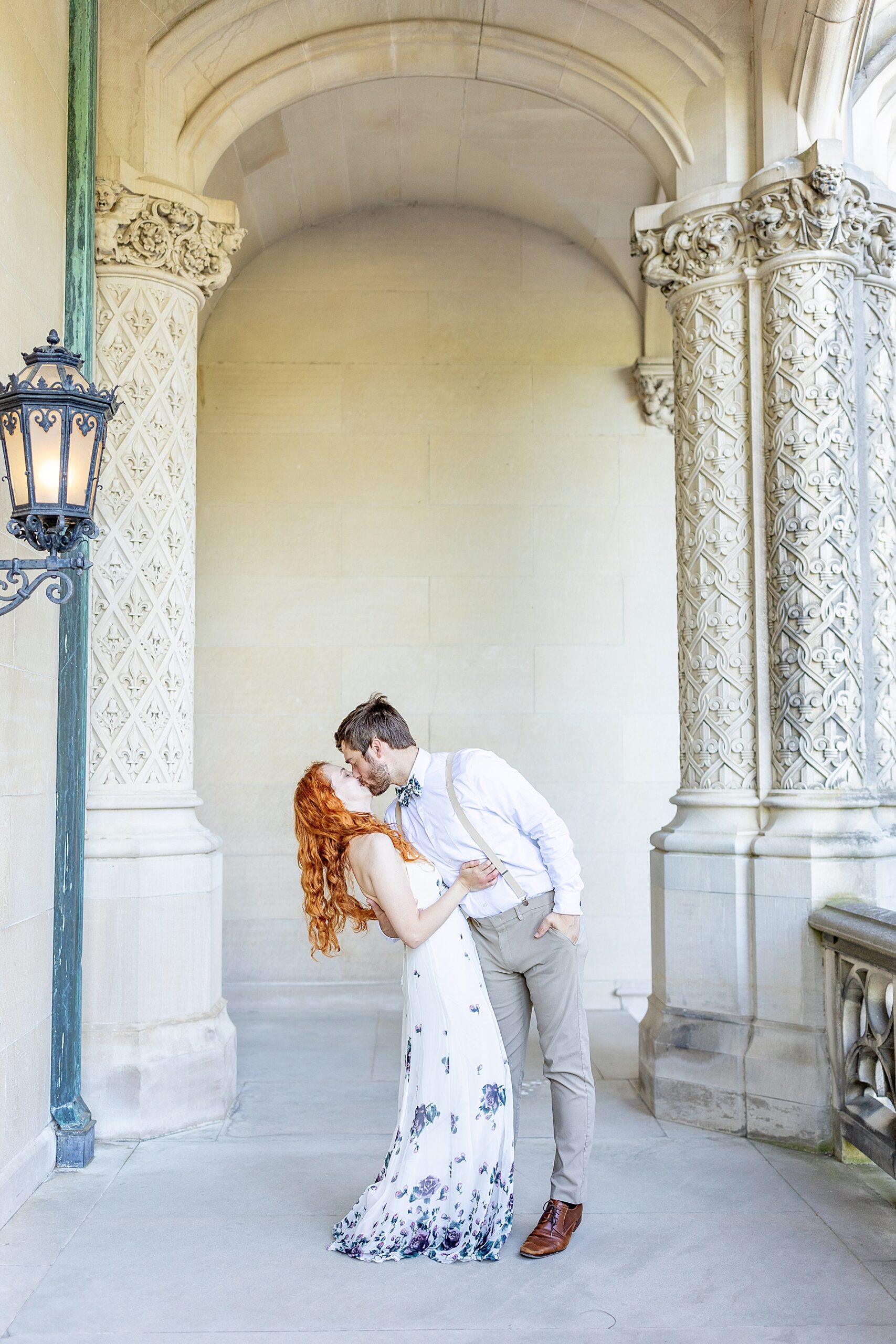 couple kiss in archway of Biltmore Estate mansion