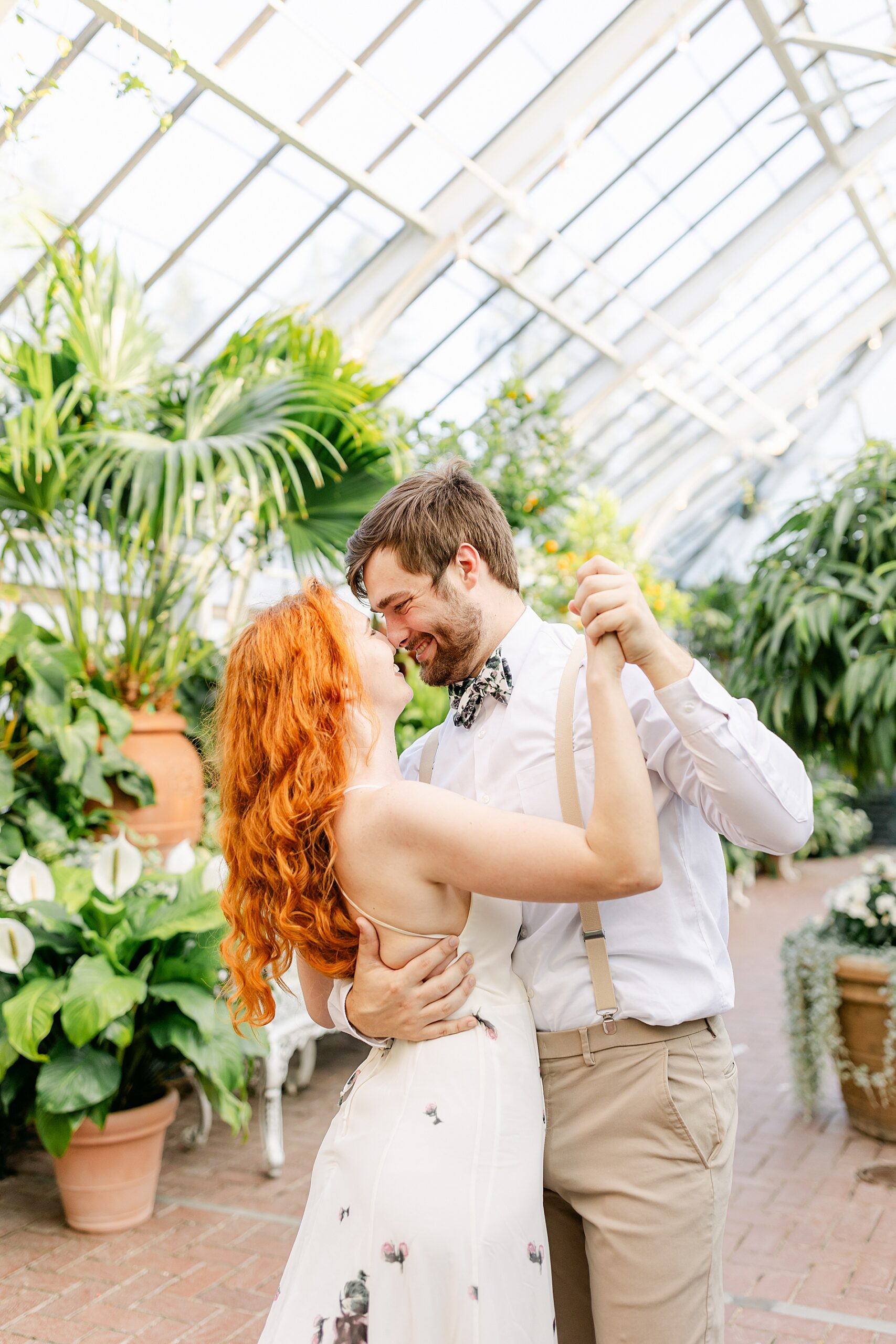 couple dance in greenhouse during engagement photos