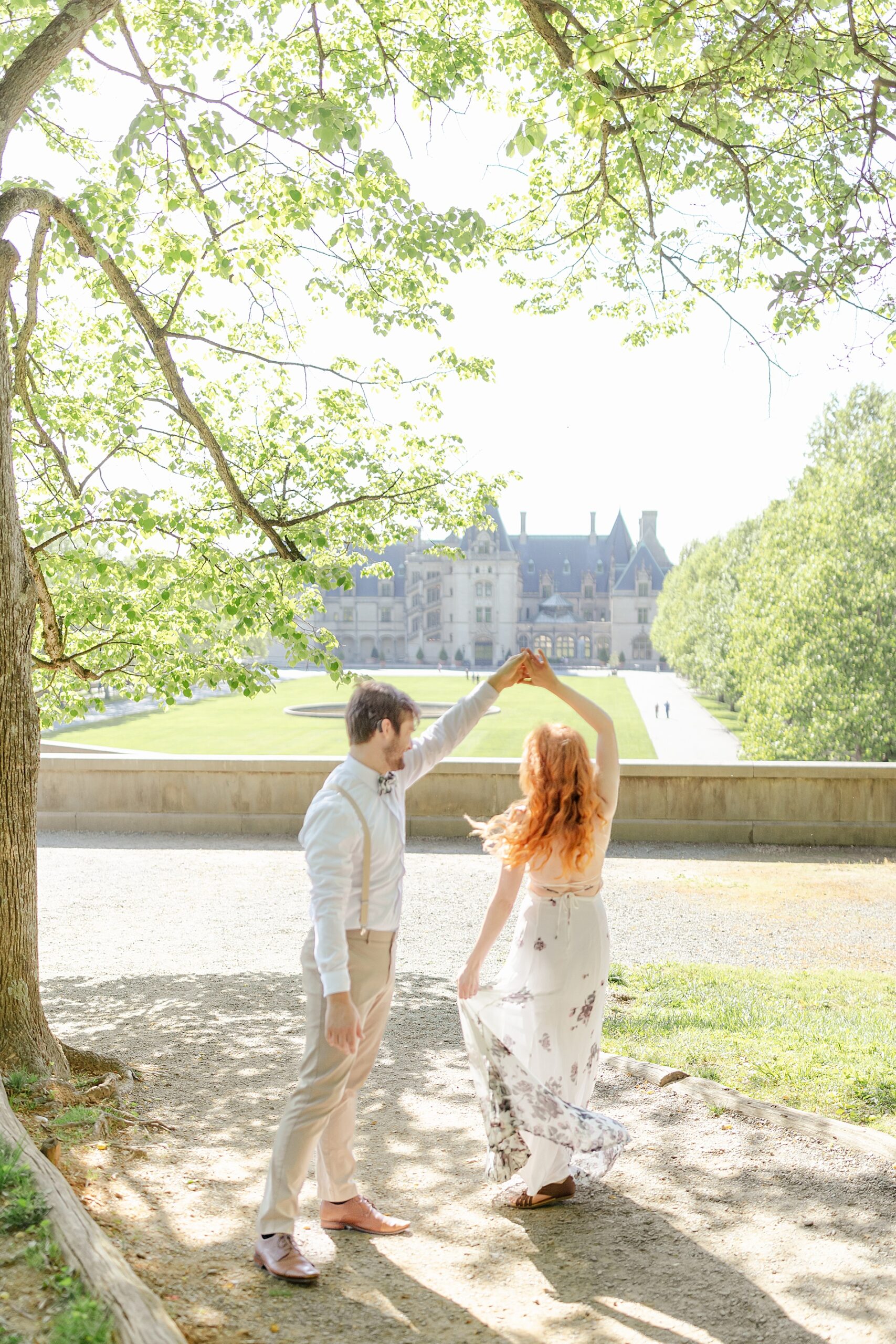 man spins his fiance during Romantic Biltmore Estate Engagement Session