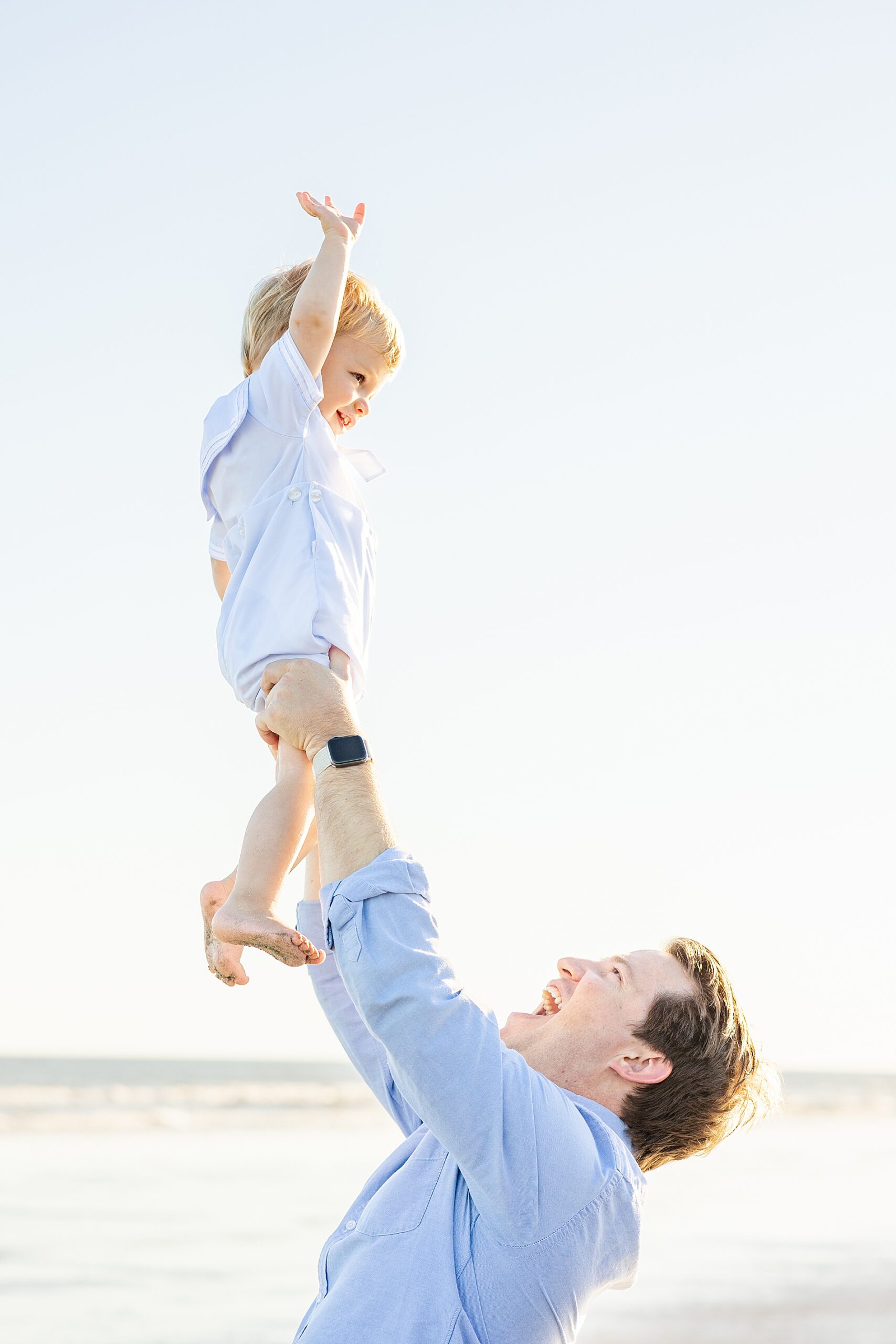 dad lifts his son in the air