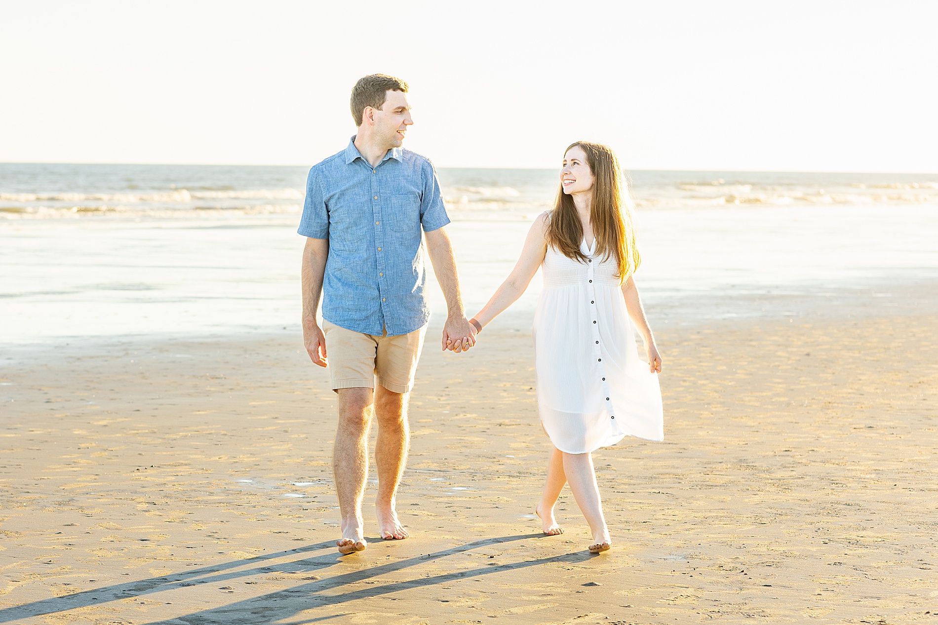 couple hold hands on the beach