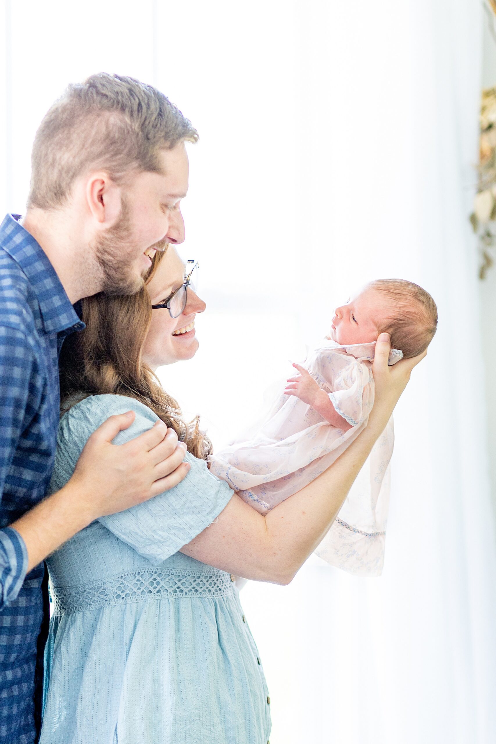 parents hold up their baby girl