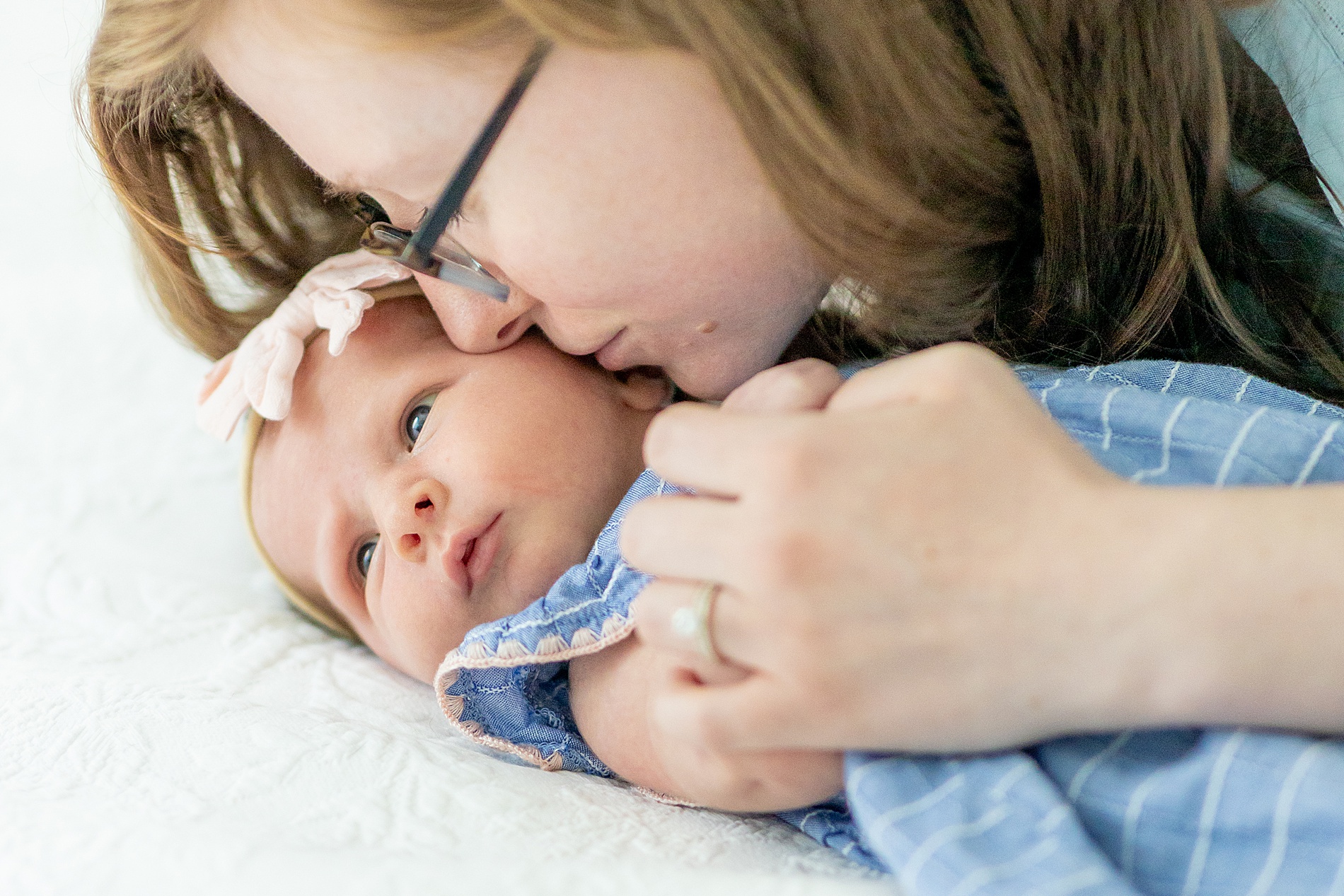 mom kisses newborn's cheek 