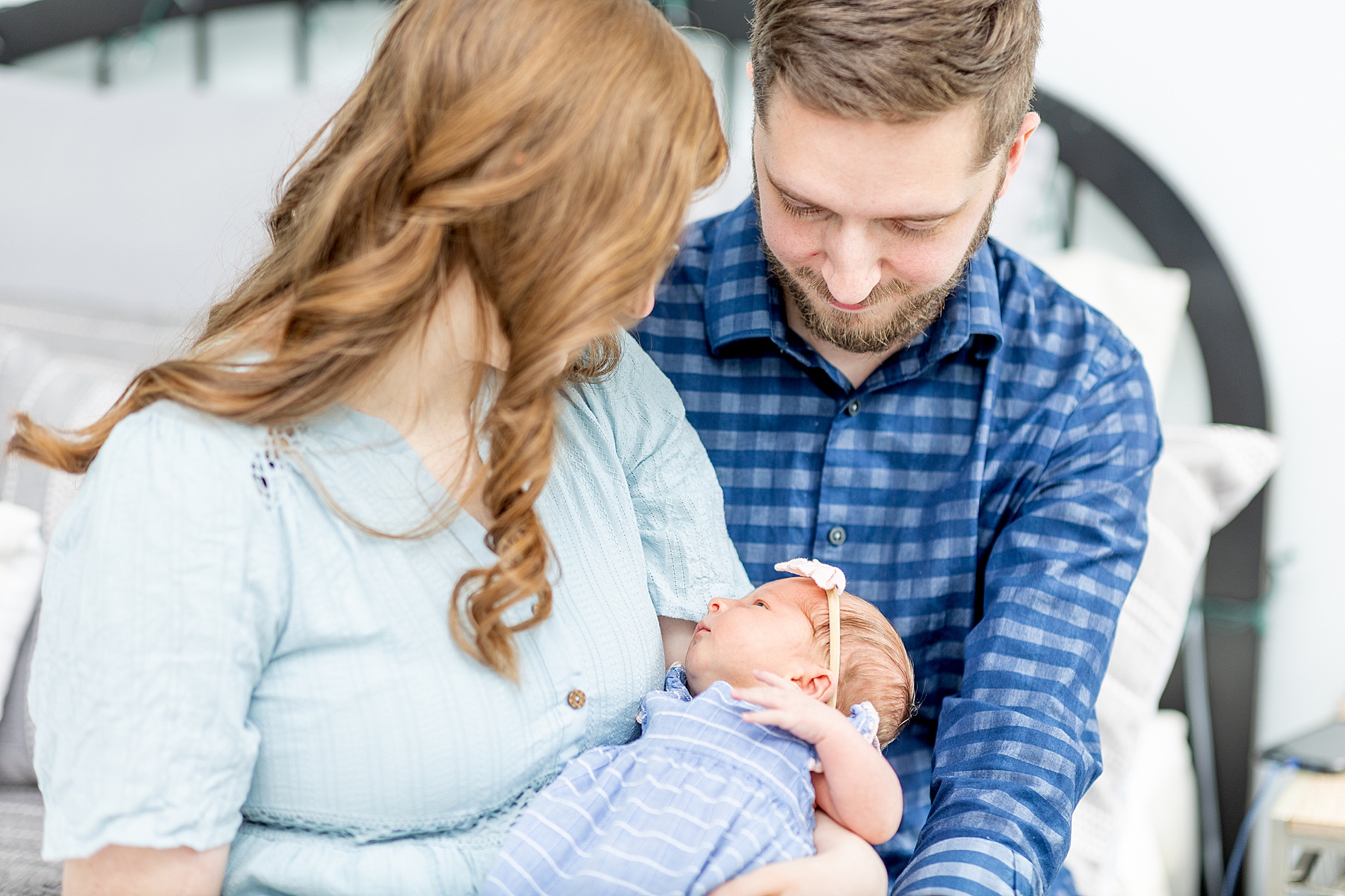 parents look down at their newborn girl