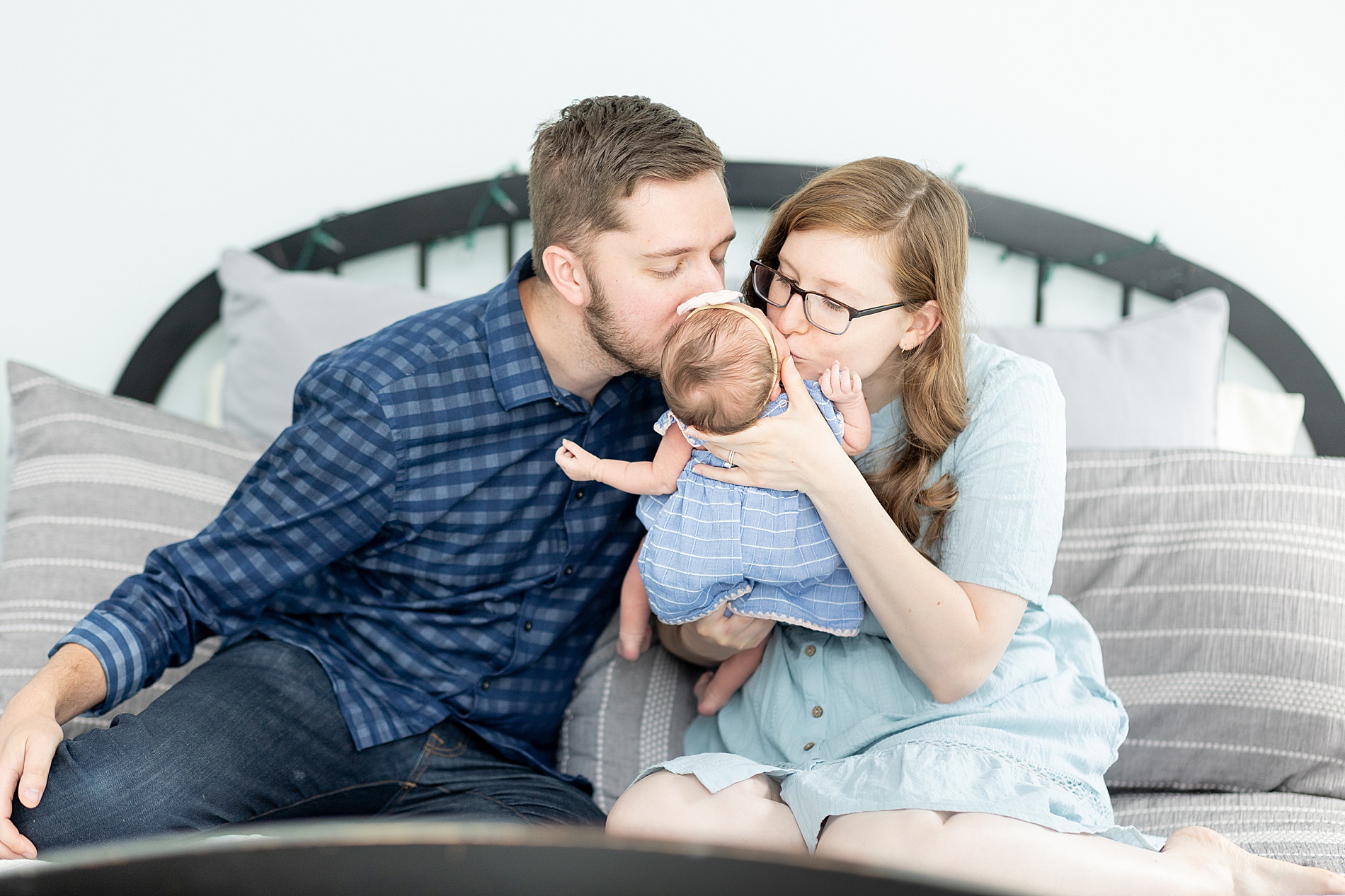 parents kiss their baby girl