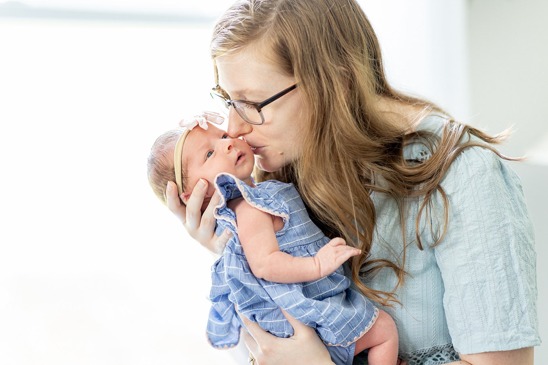 mom kisses her newborn girl