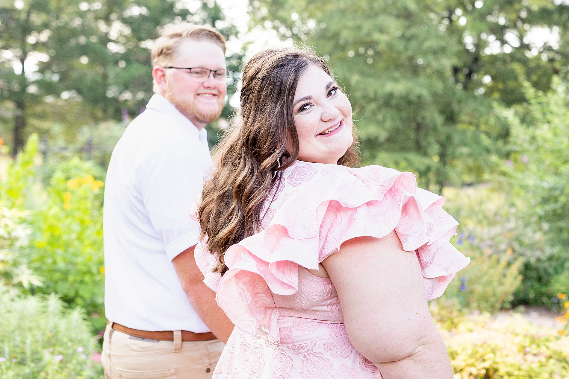 couple walk through grassy path in garden