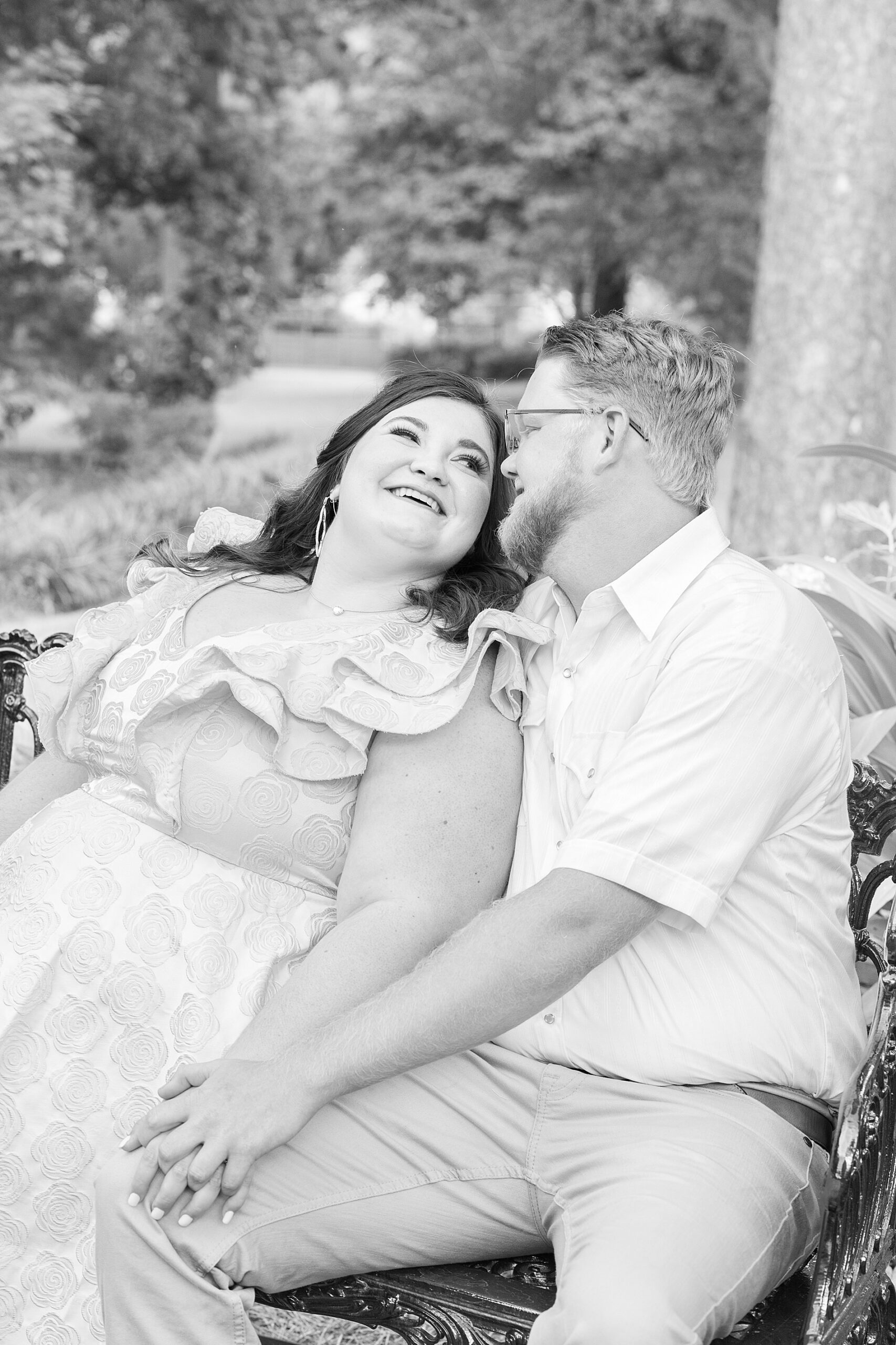 couple sit together on bench in garden