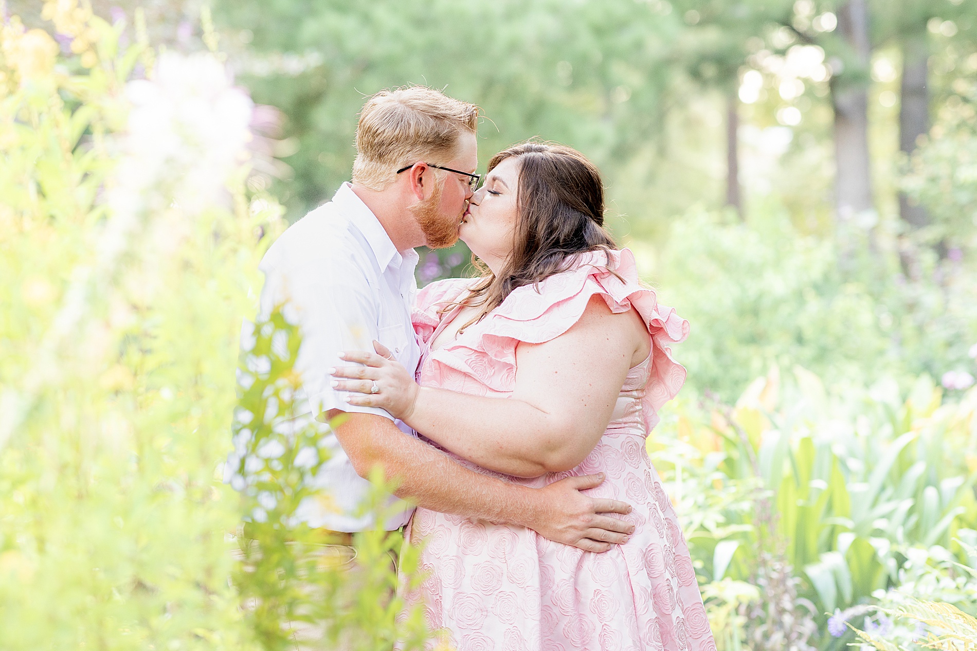 engaged couple kiss during Dreamy Engagement Session at Tyler Rose Garden