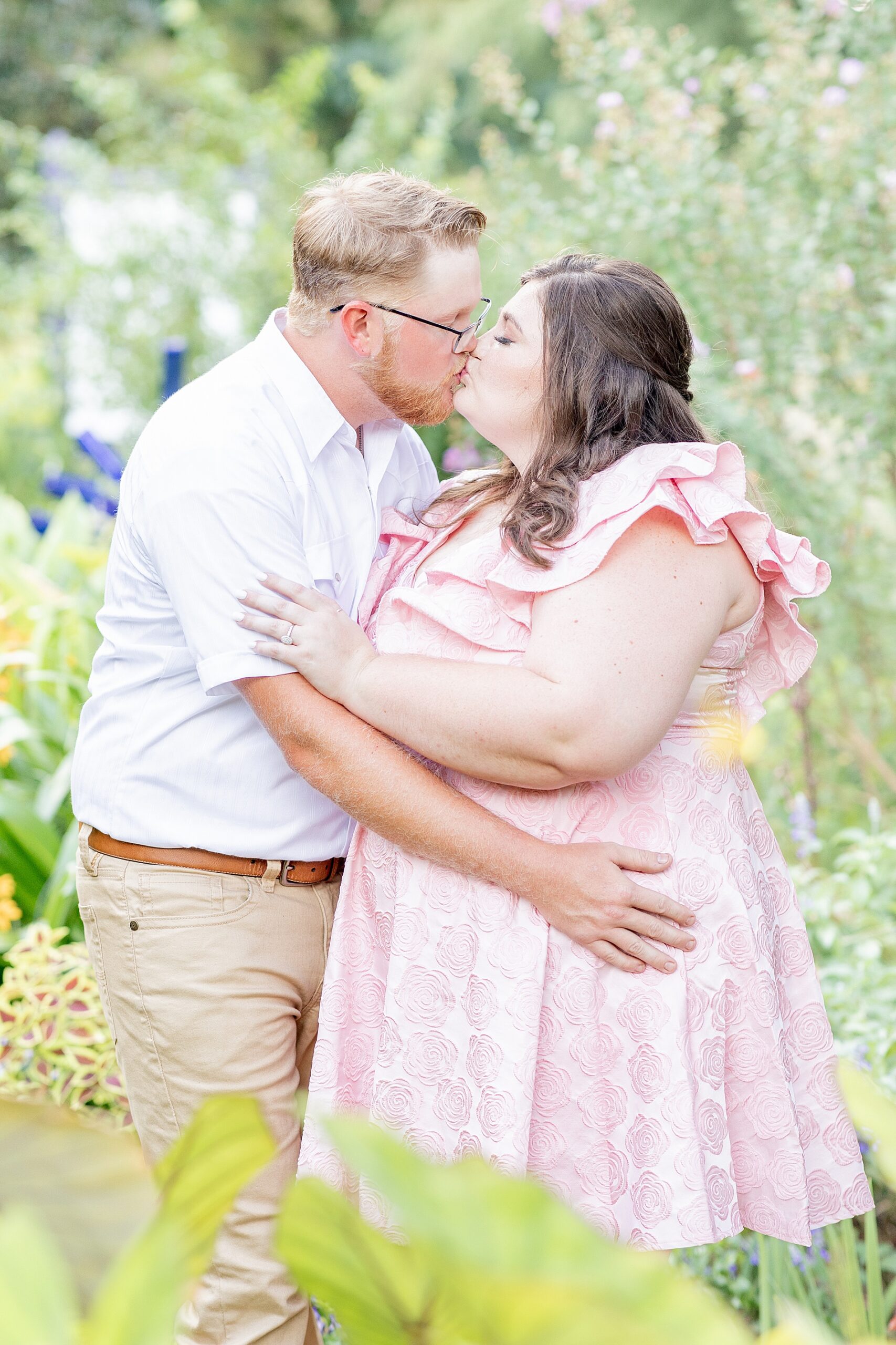 couple kiss in garden during engagement session