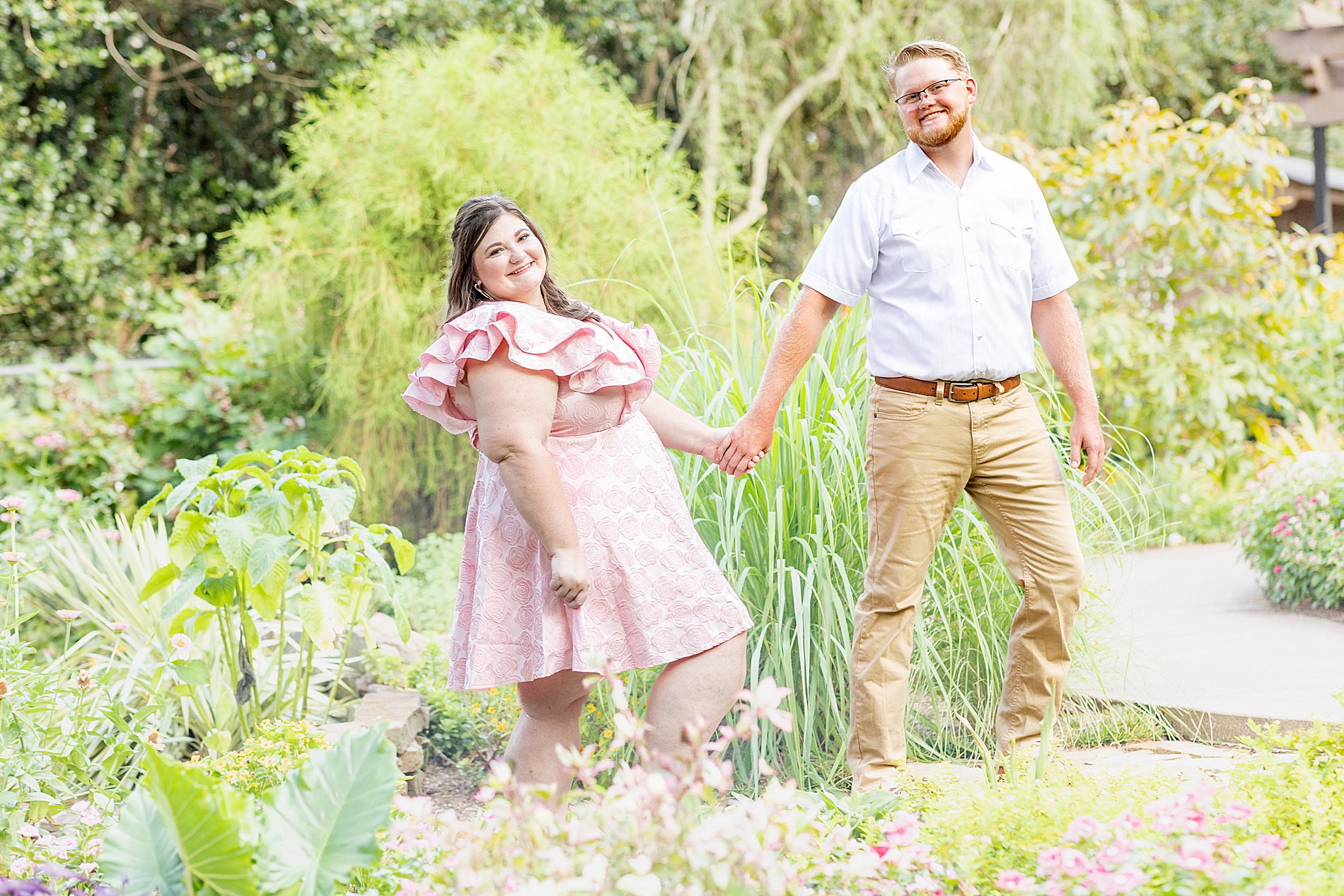 couple walk through Tyler Rose Garden holding hands