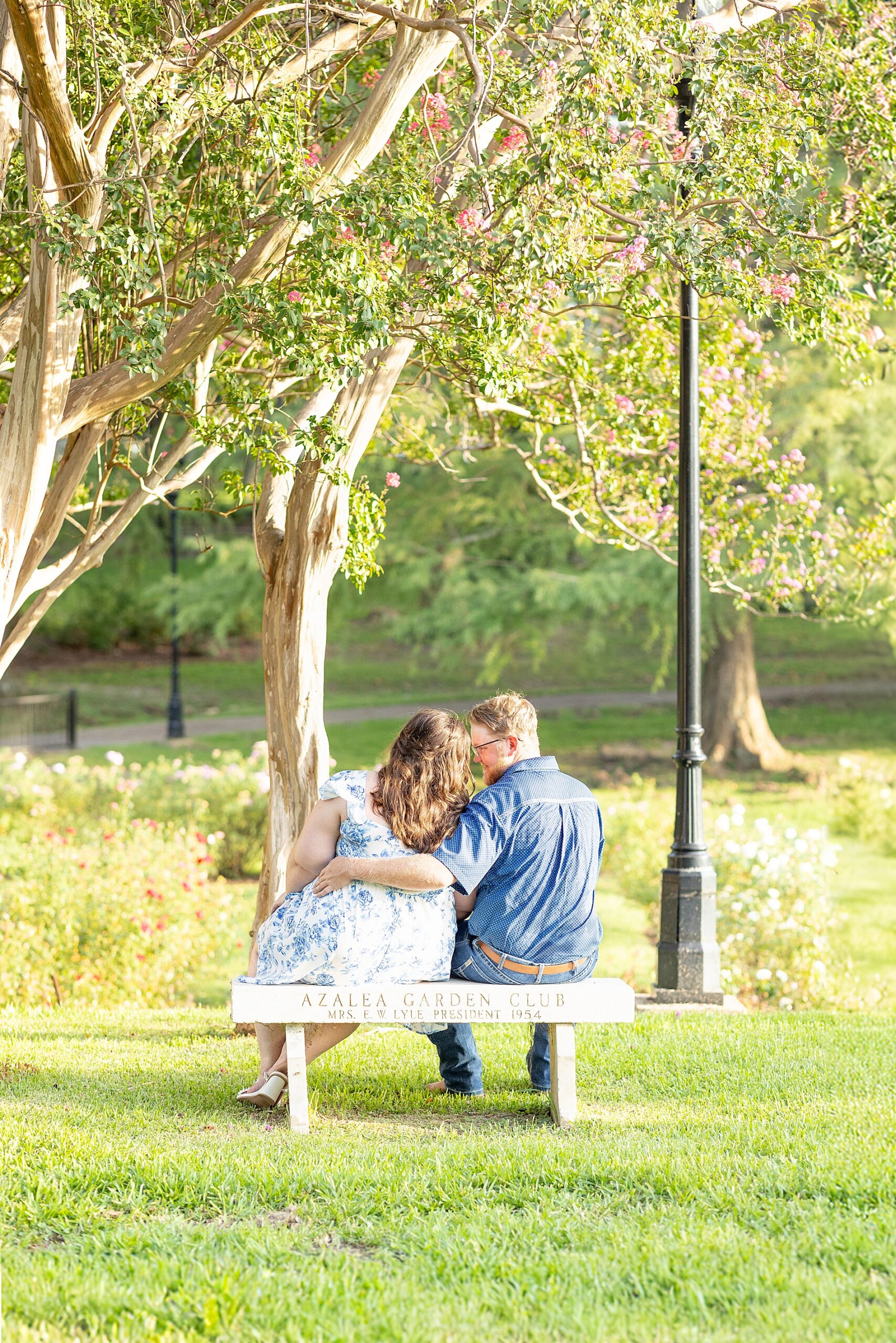 couple sit on bench together in garden