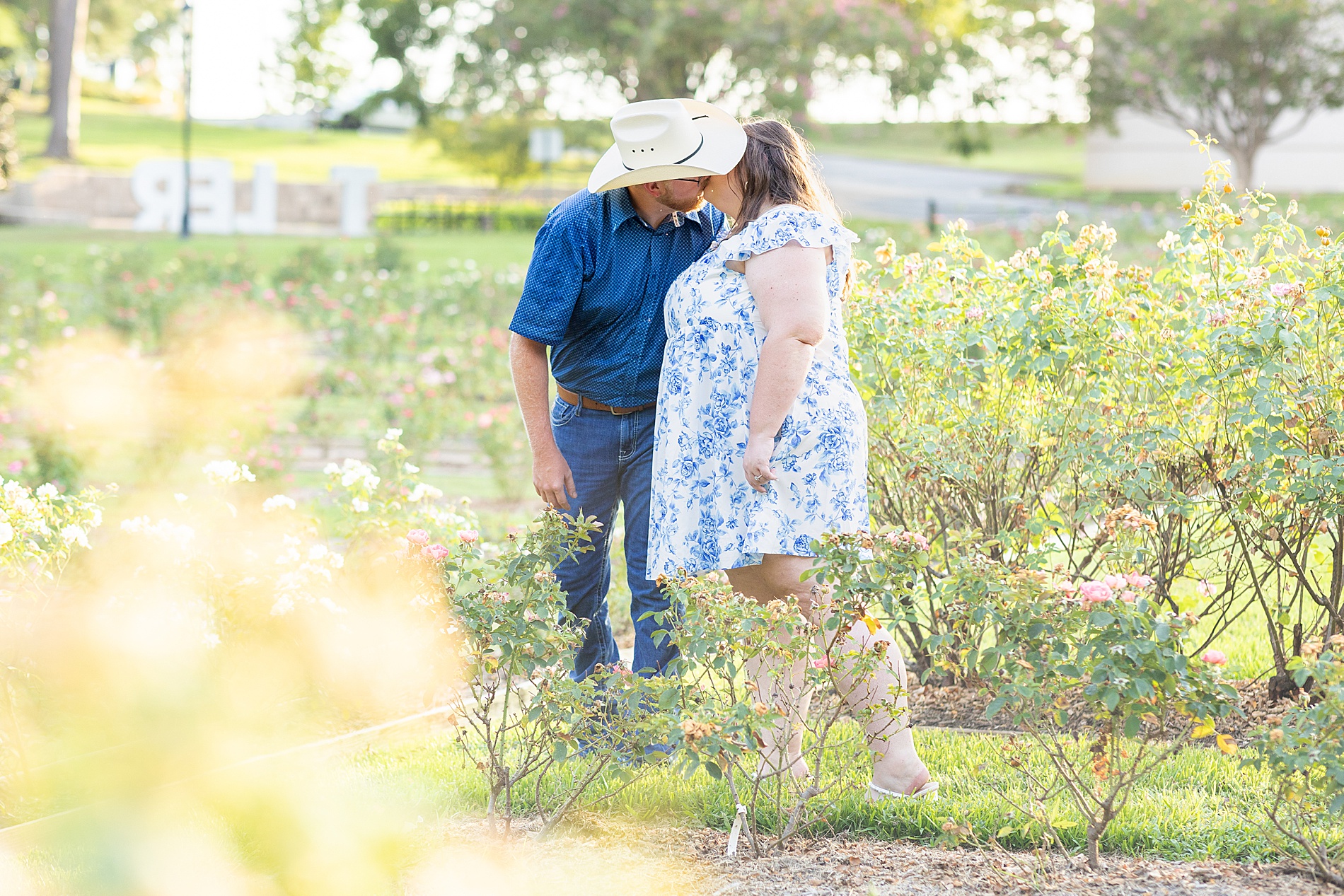 engaged couple kiss during Dreamy Engagement Session at Tyler Rose Garden