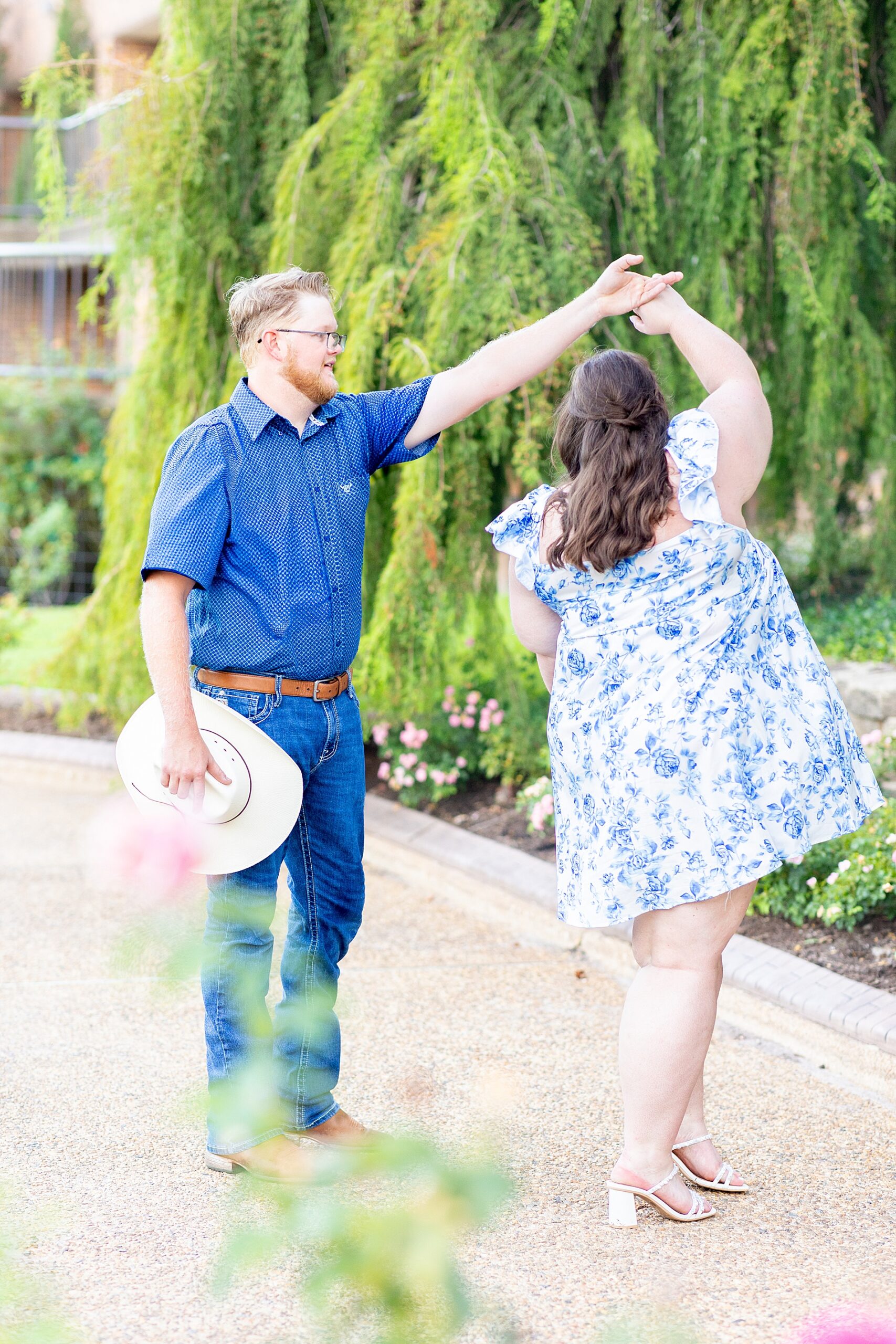 man spins his fiance around as they dance together 