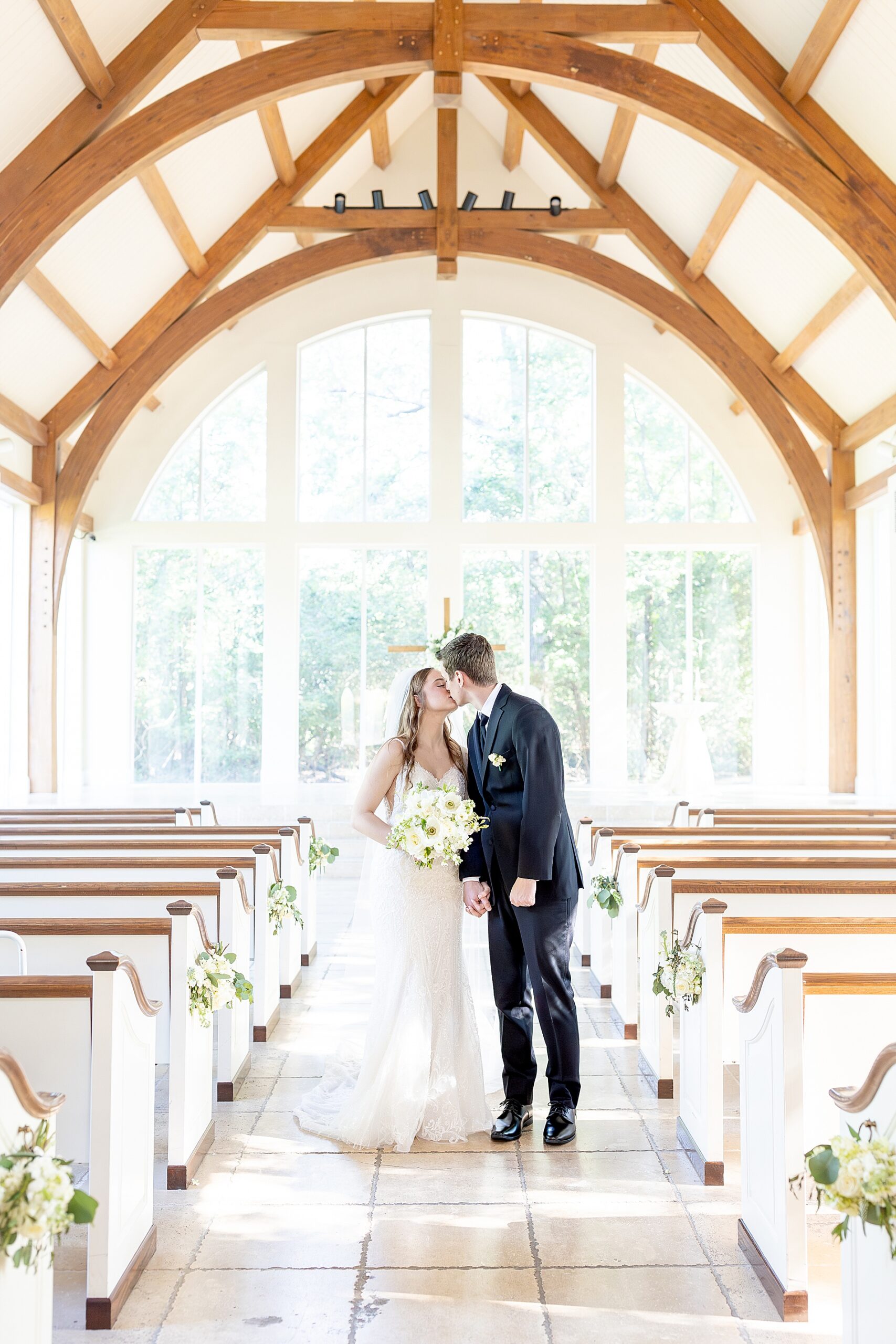 newlyweds kiss inside chapel at Ashton Gardens