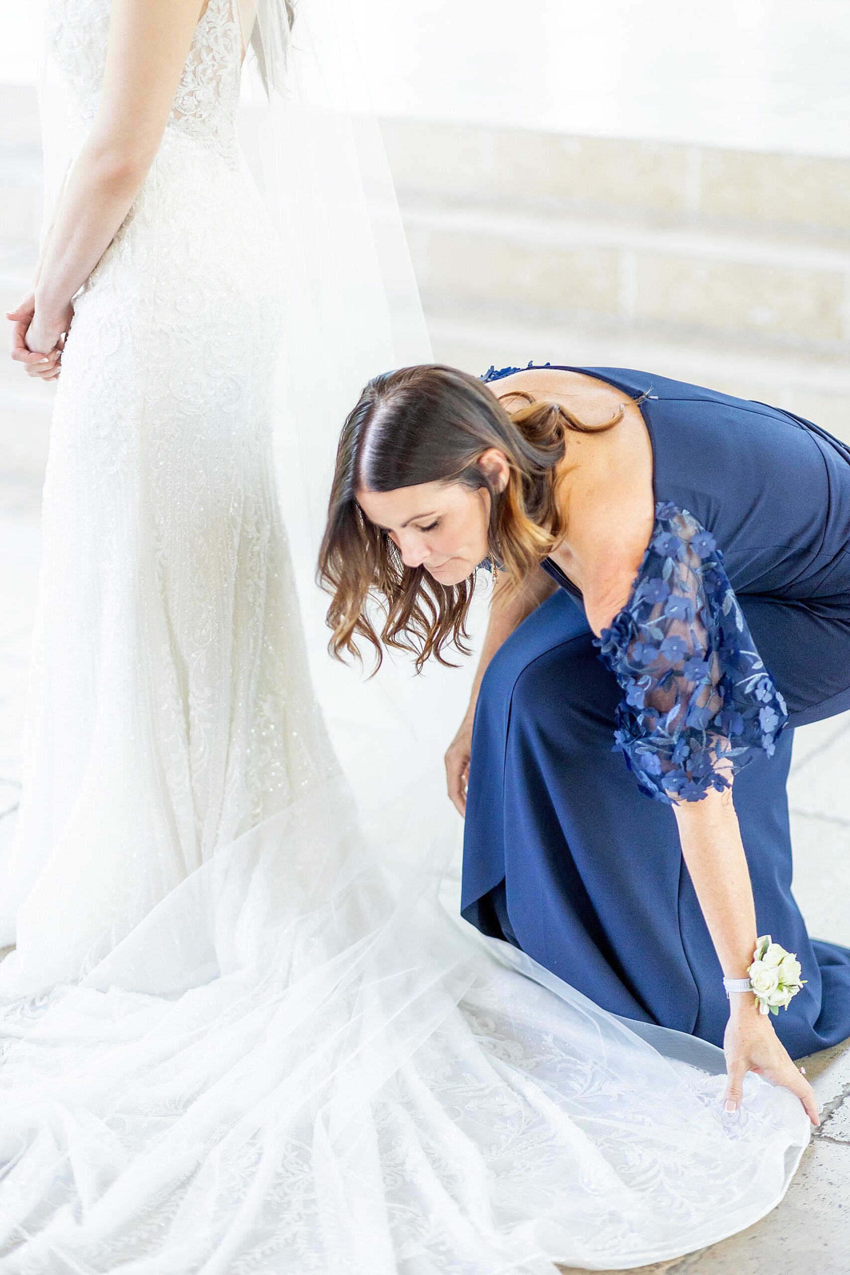 mom straightens wedding dress