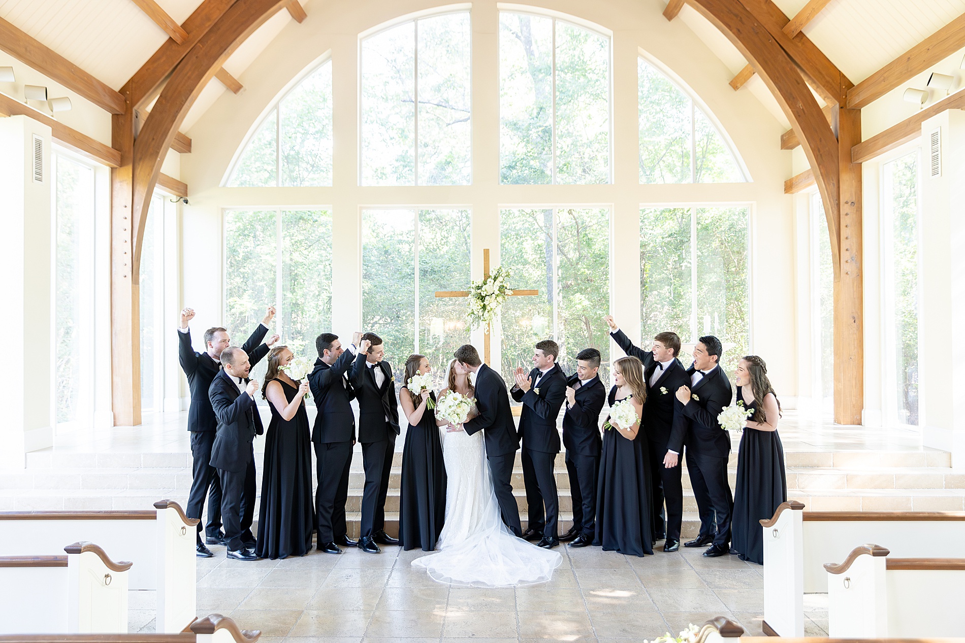 newlyweds kiss surrounded by bridal party