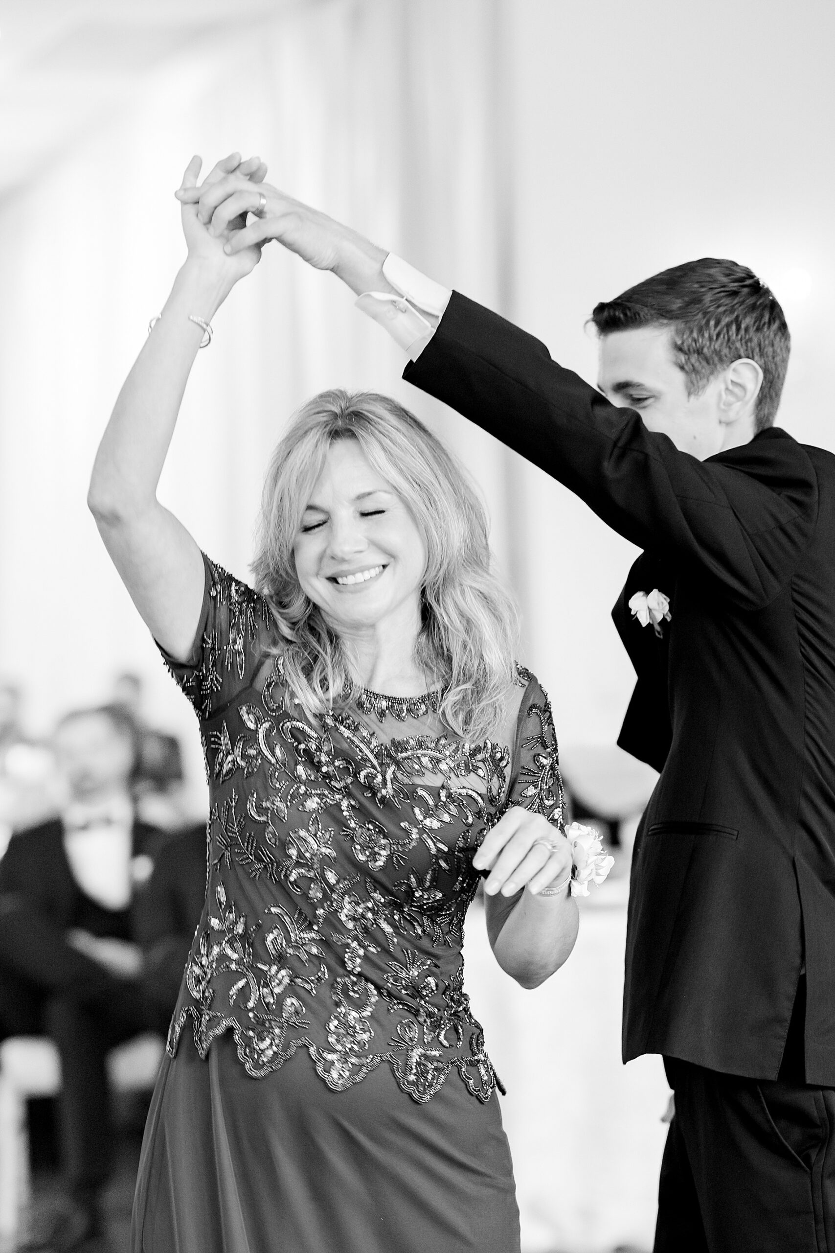 groom spins his mom around during parent dance