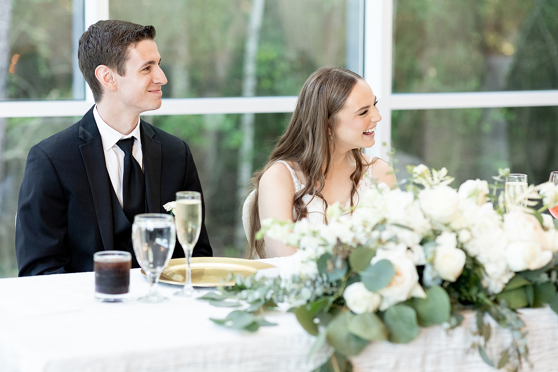 newlyweds laugh during wedding speeches 