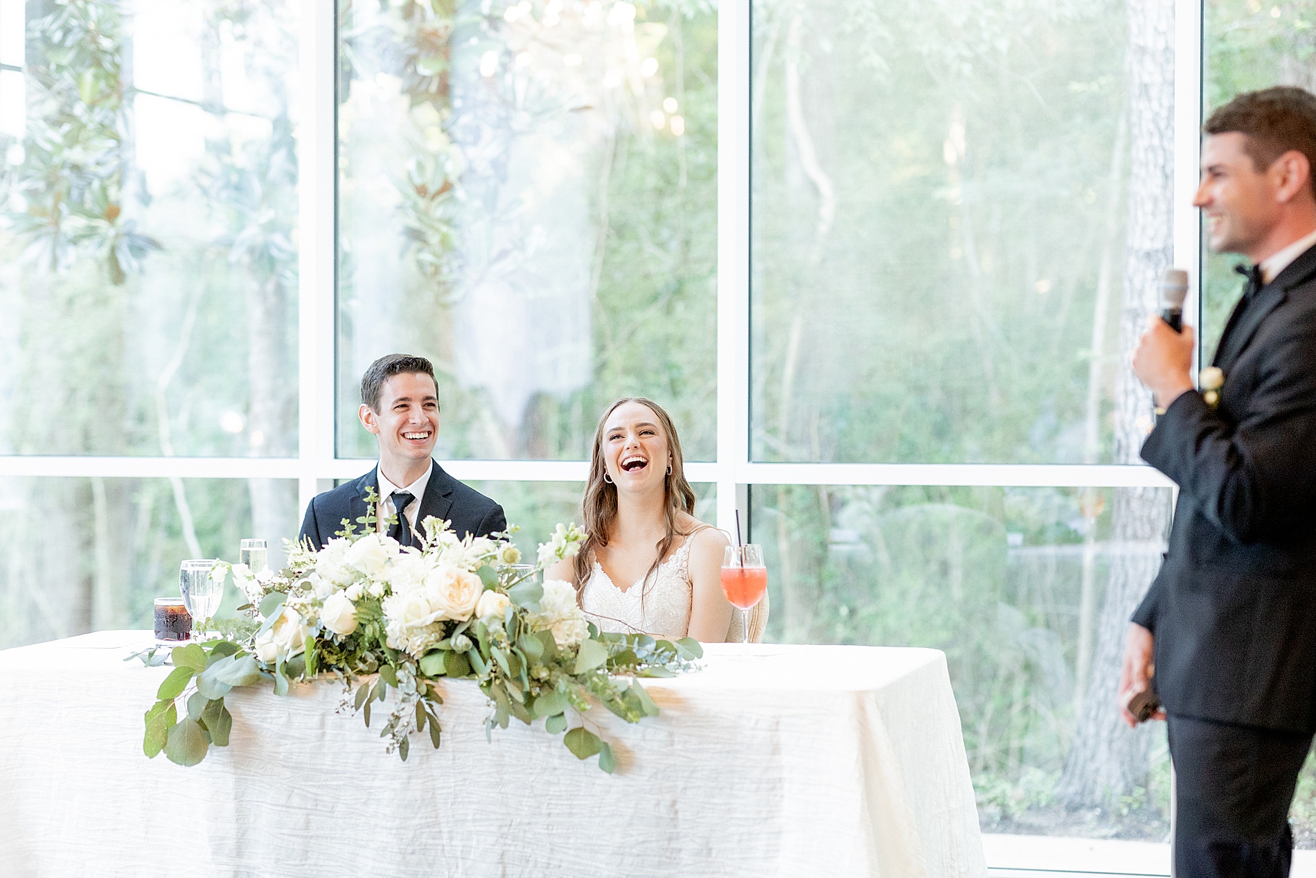 candid photo of couple laughing during wedding toast