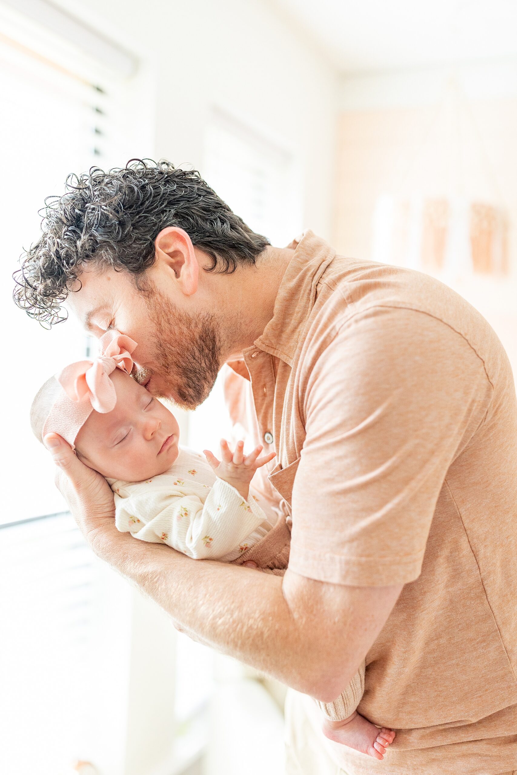 dad kisses newborn girl