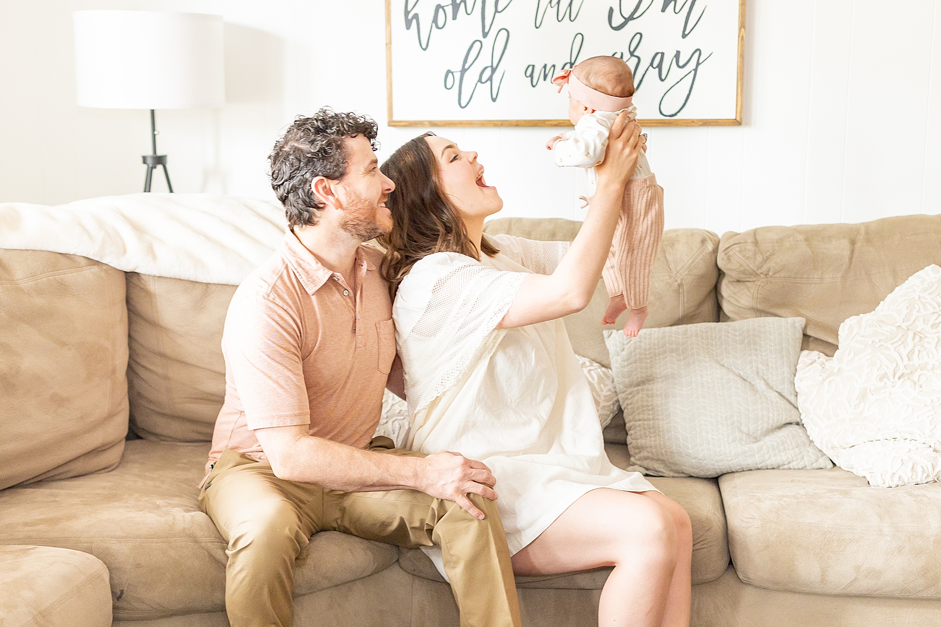 parents hold newborn in the comfort of their homw