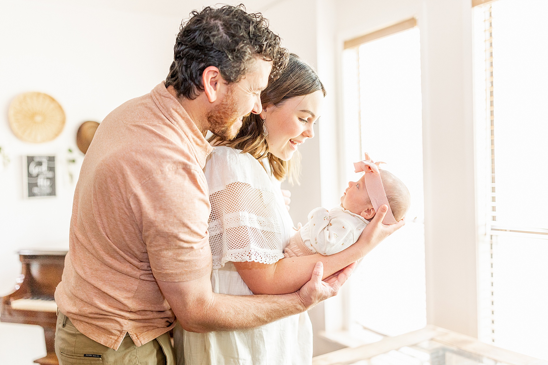 new parents look lovingly at newborn girl