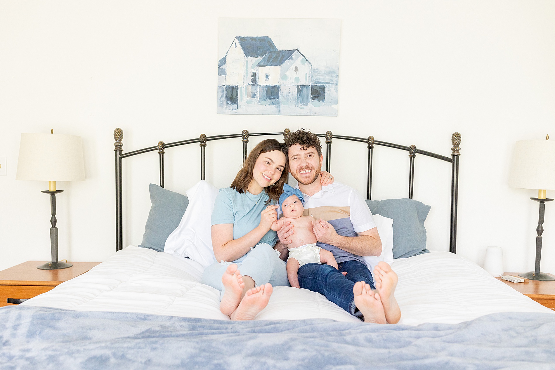 parents with newborn sitting on bed