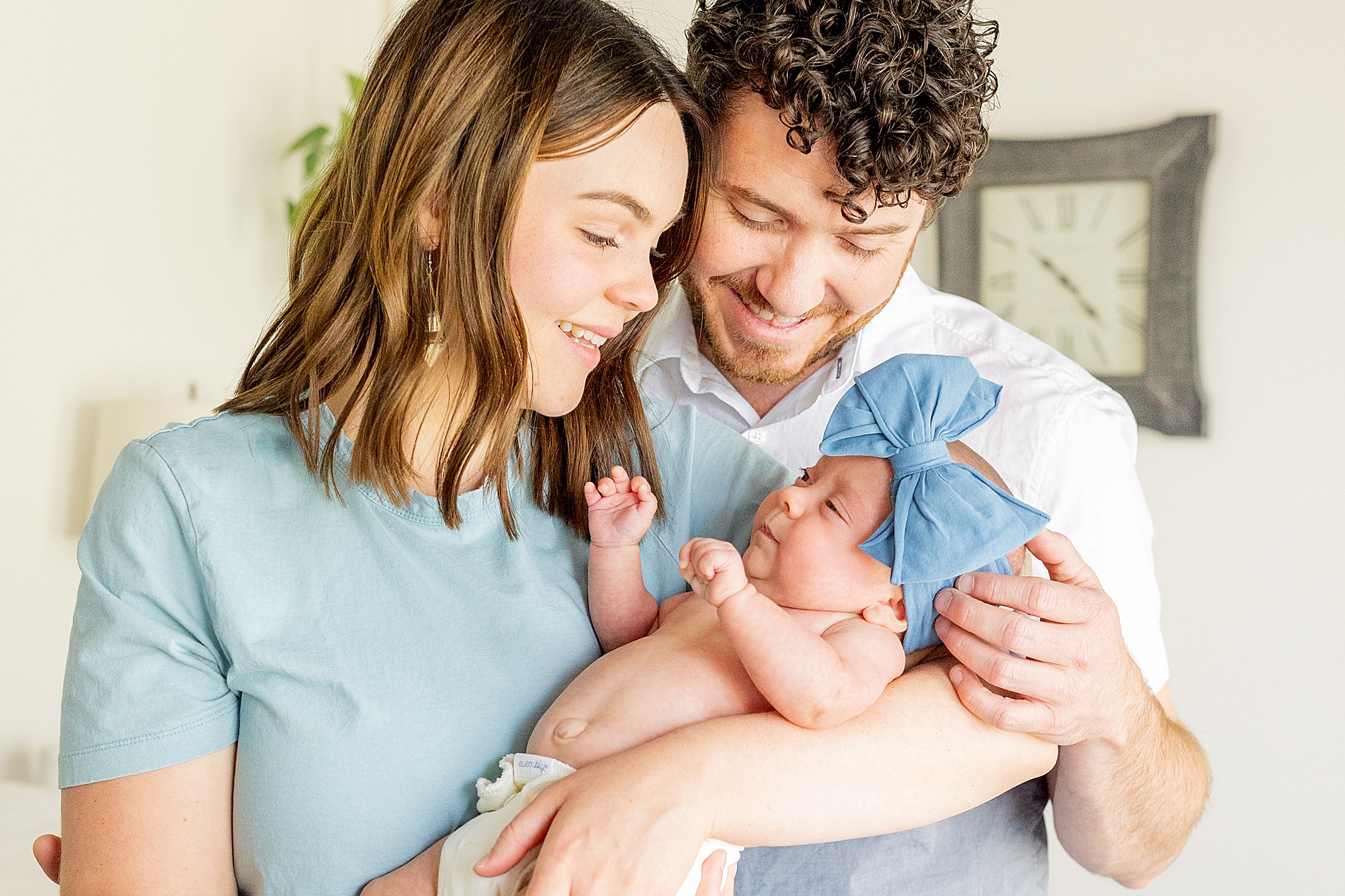 new parents look down at newborn