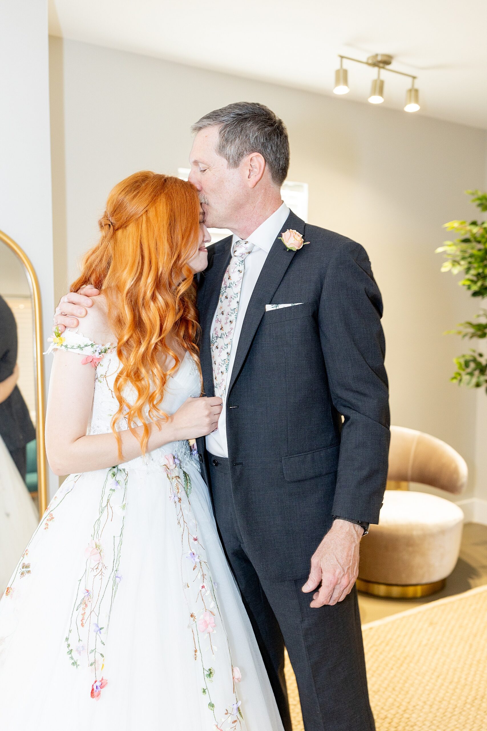 father of the bride kisses bride's head