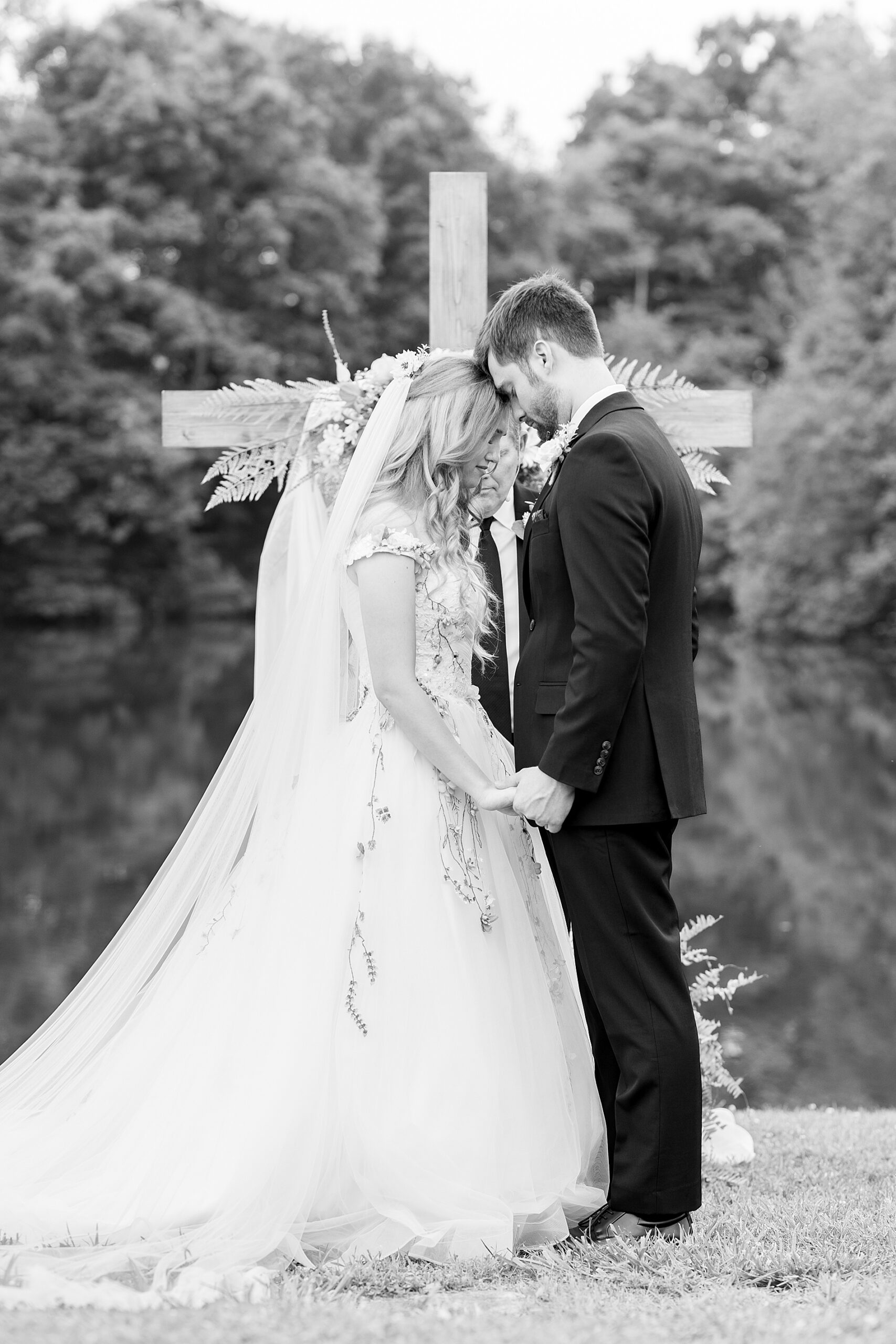 bride and groom pray together during wedding ceremony 