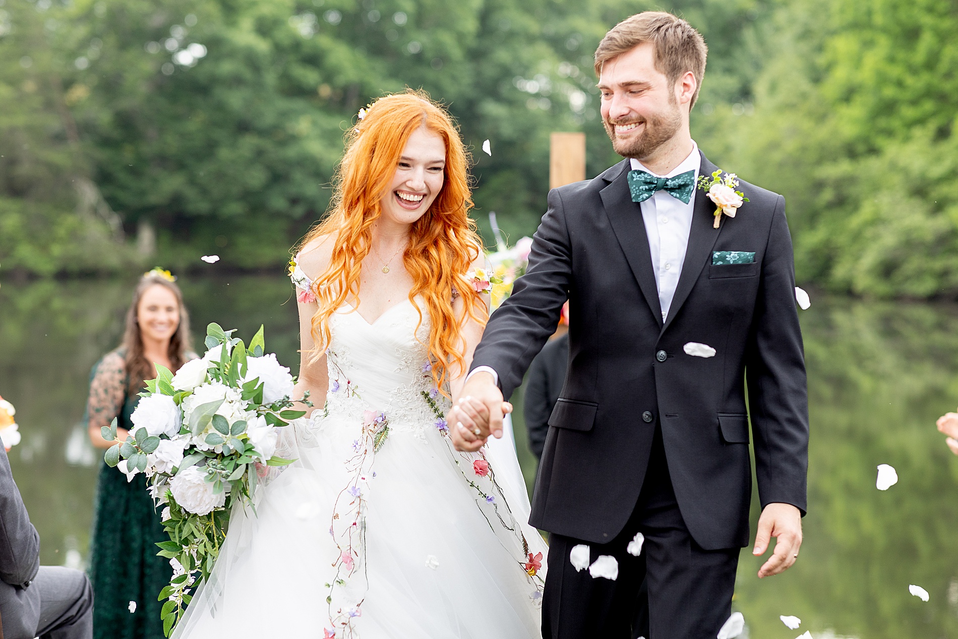 guests throw flower petals during wedding ceremony exit