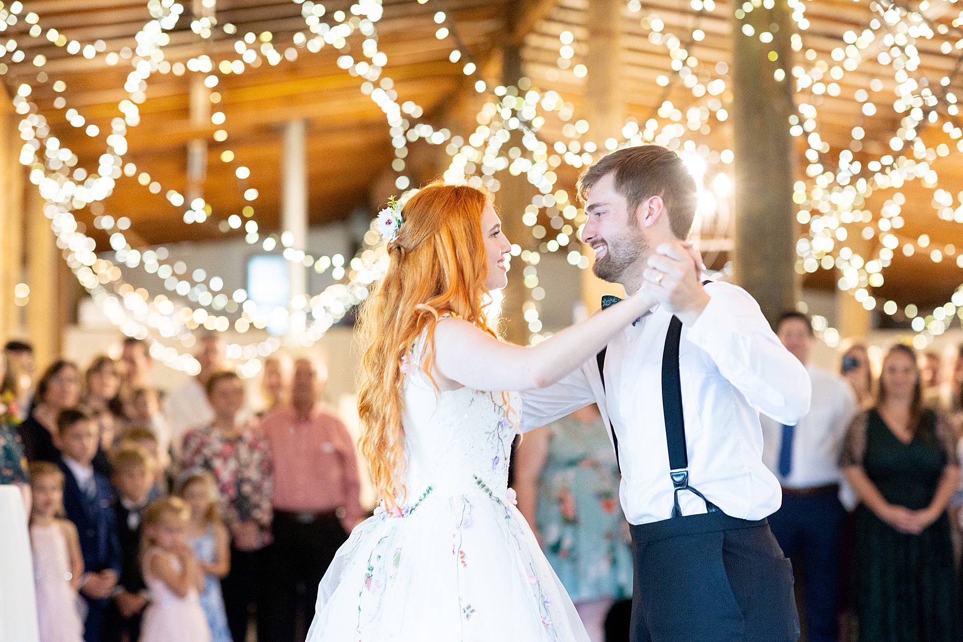 newlyweds share first dance under twinkling lights