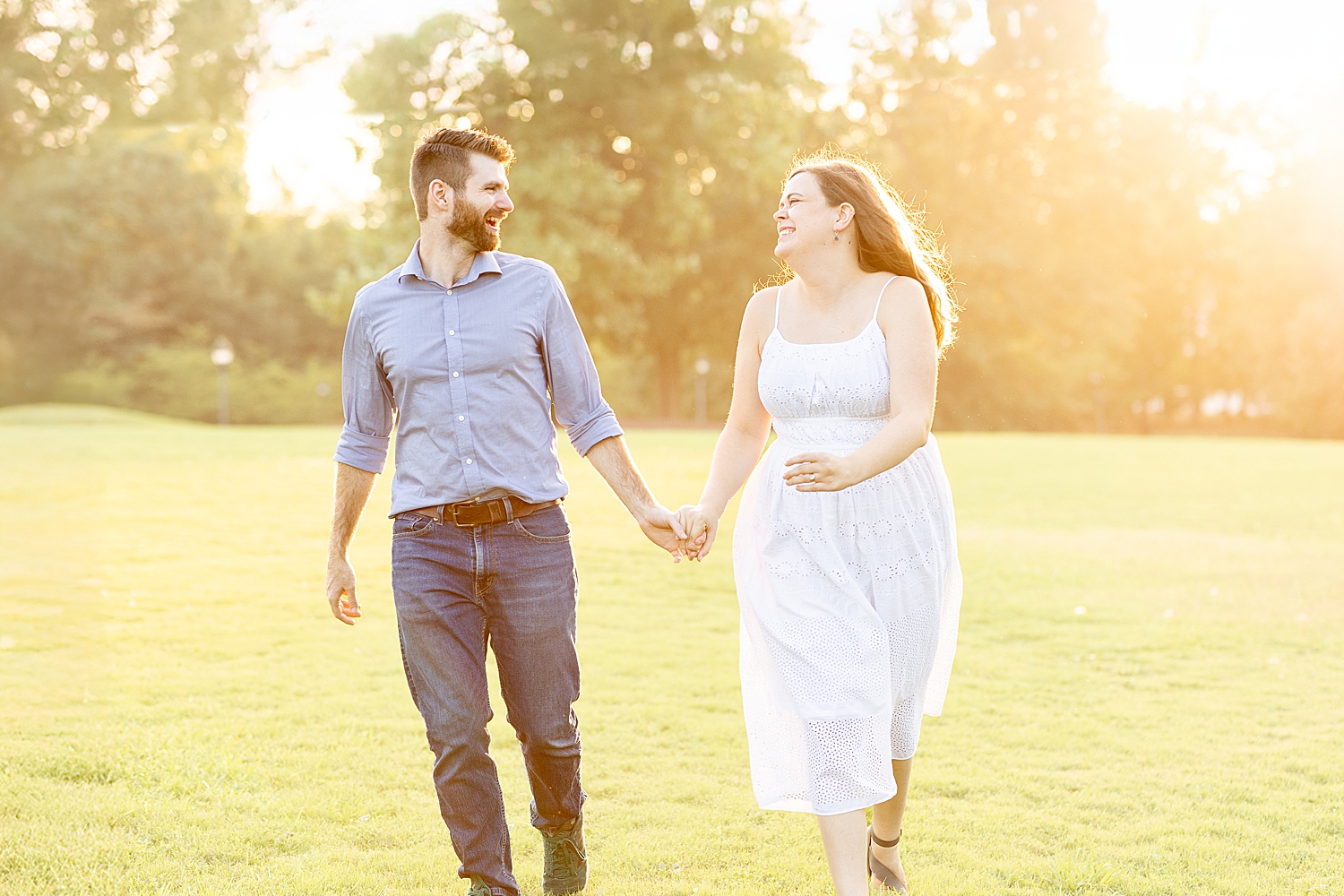 husband and wife hold hands as the sun sets behind them