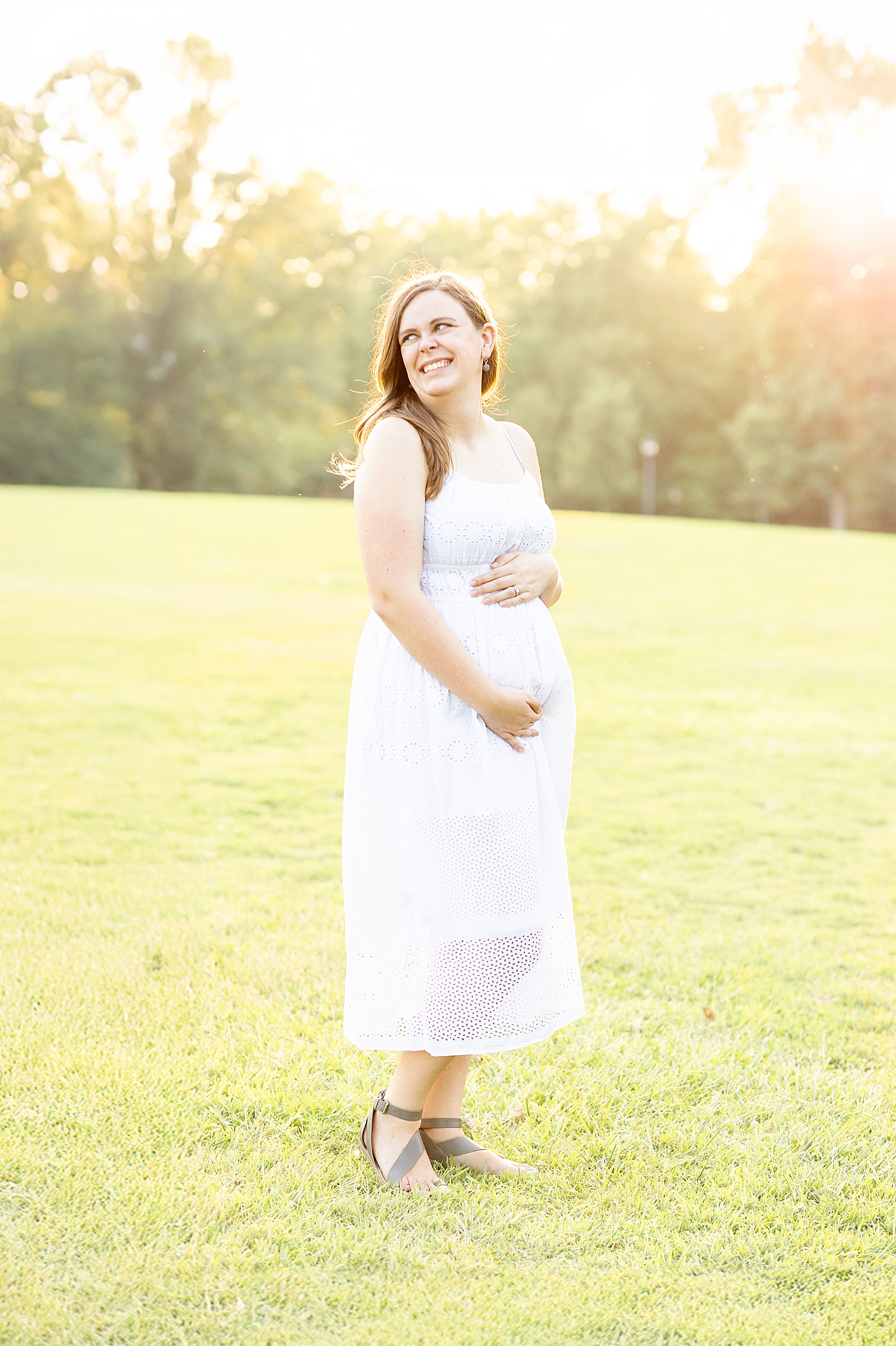 woman shows off baby bump during Legacy Park Family Session in Greenville, SC