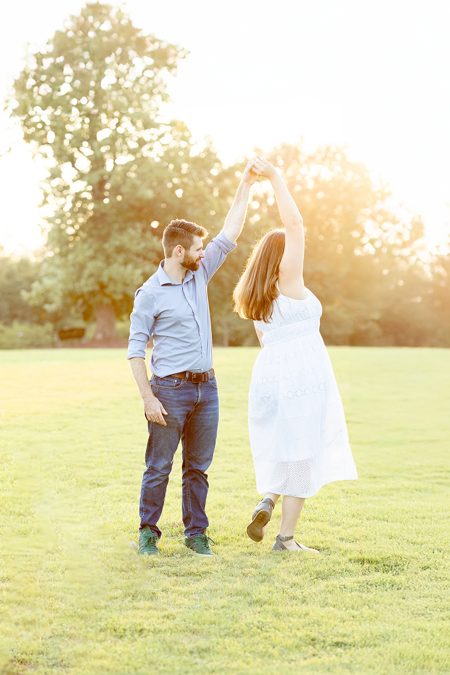 man spins his wife around during portrait session