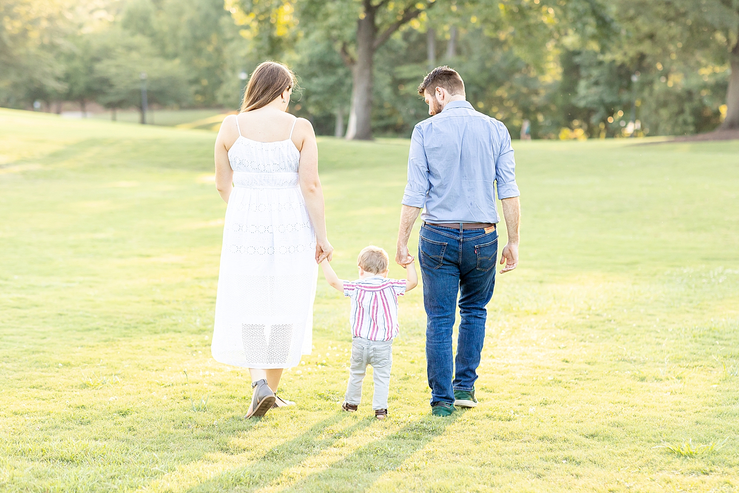 parents hold their son's hand as they walk together