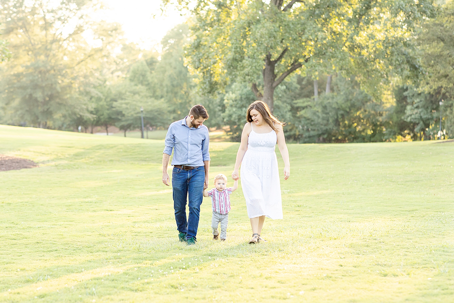 family of three walk together holding hands