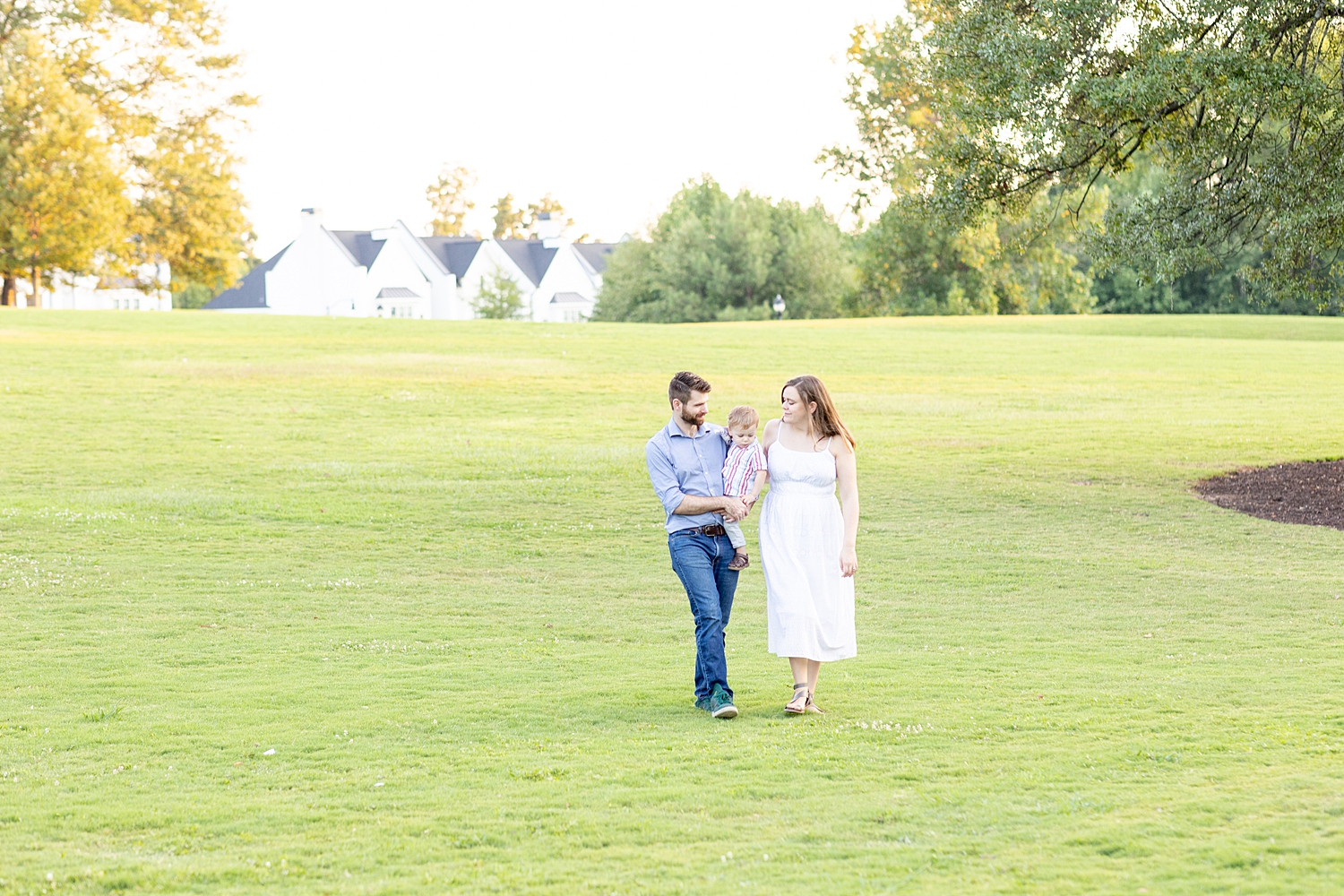 family of three walk together during Legacy Park Family Session in Greenville, SC