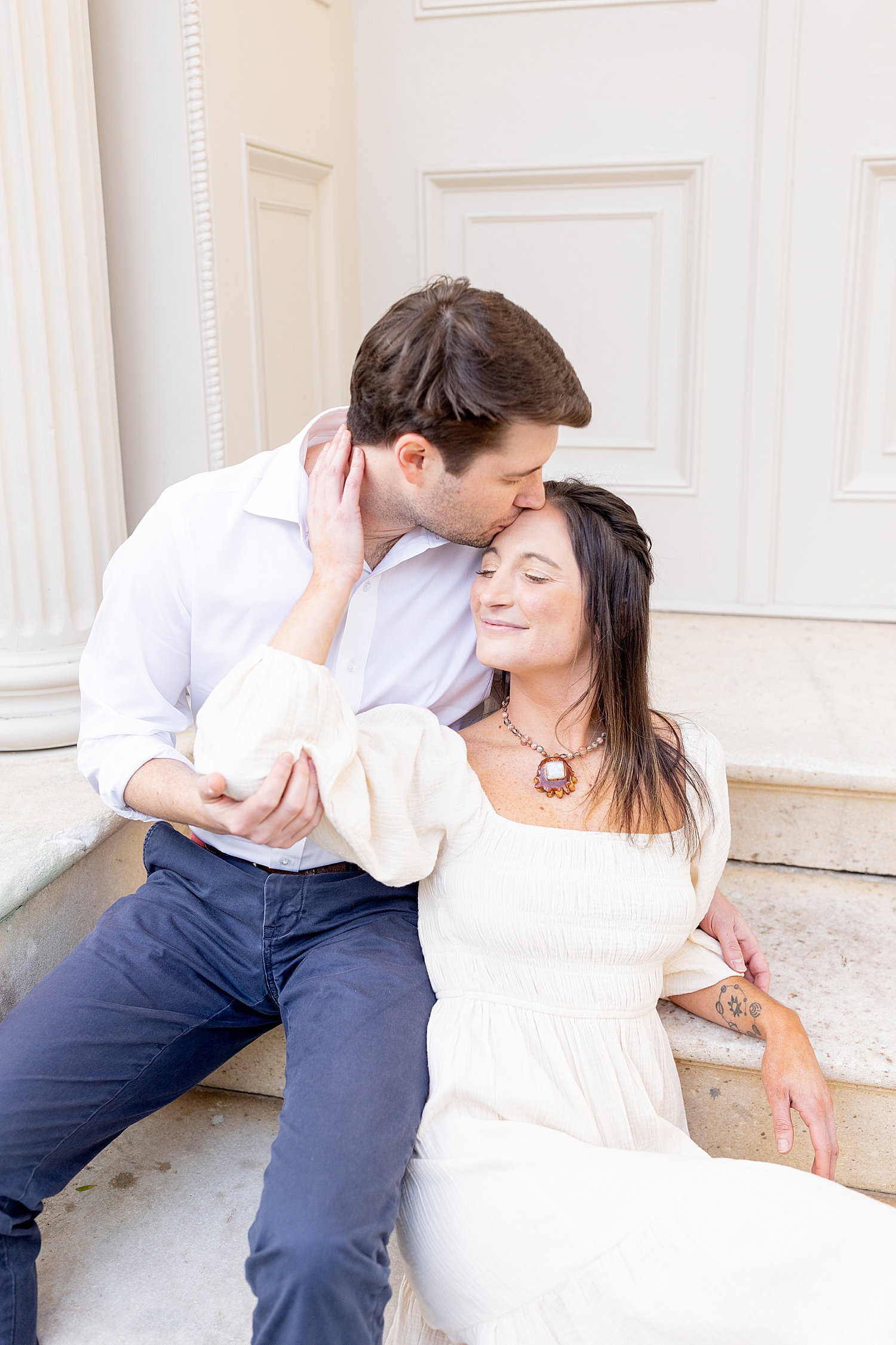 couple kiss as they on staircase 