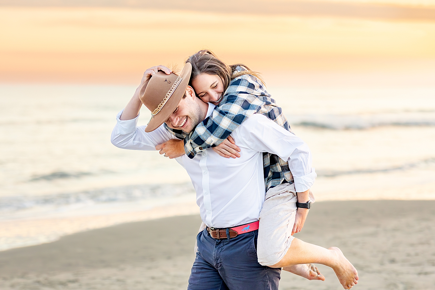 guy carries his fiance as they laugh together