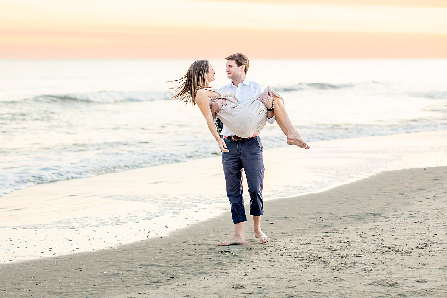 guy carries his fiance on Folly Beach