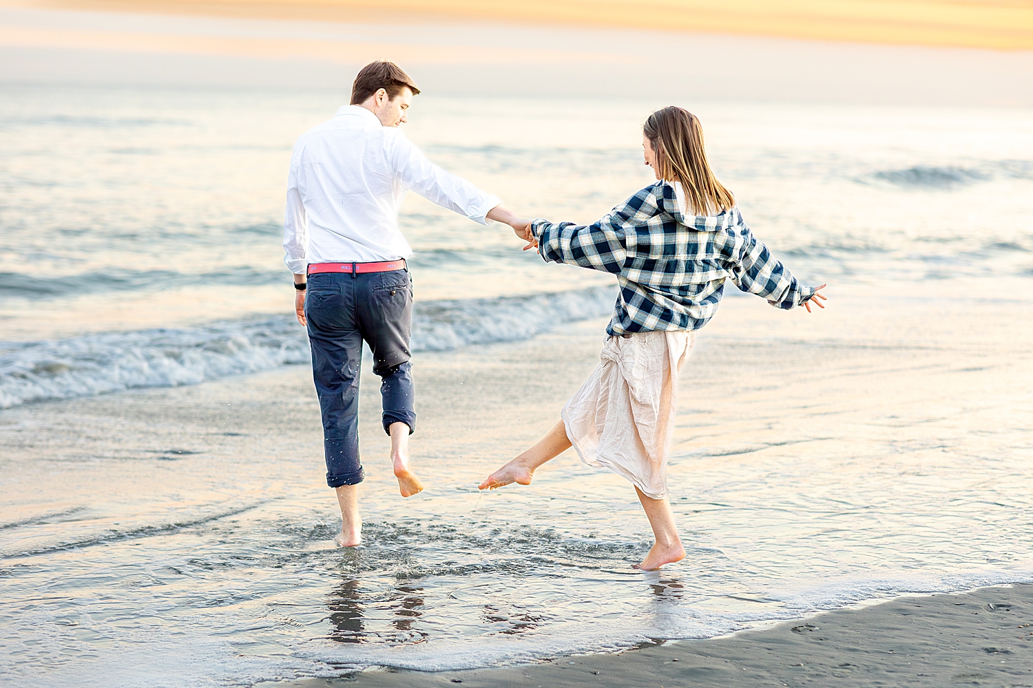 candid photos of couple kicking up the water on Folly Beach