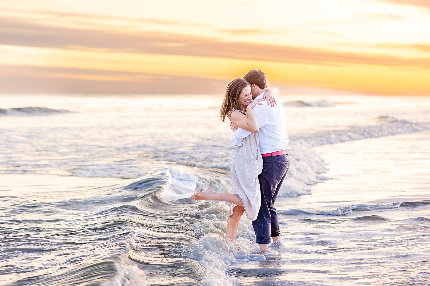 couple play in the ocean at Folly Beach